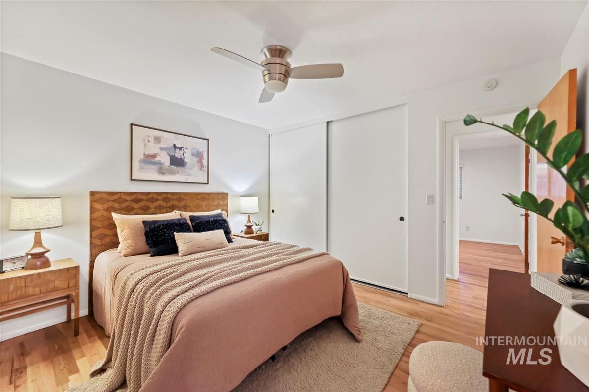 Bedroom with wood finished floors, a ceiling fan, and a closet