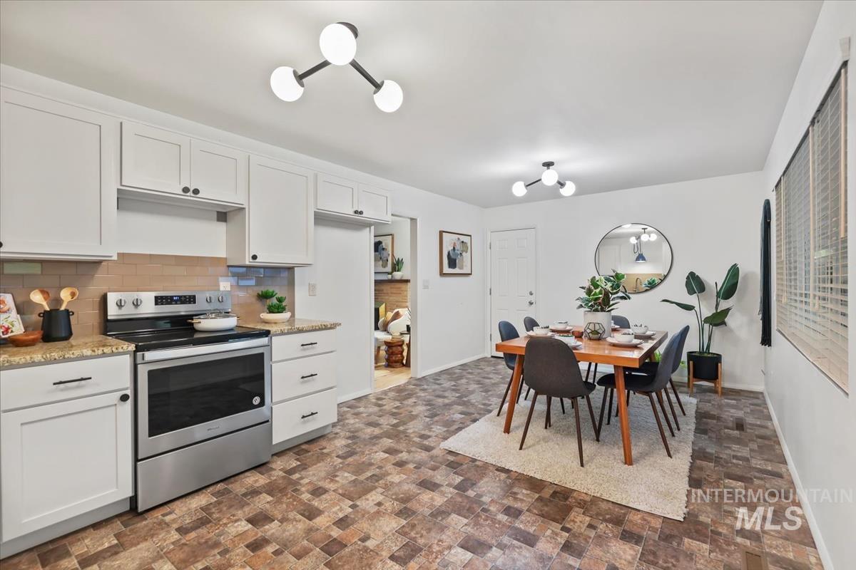 Kitchen featuring electric stove, white cabinetry, tasteful backsplash, and light stone countertops