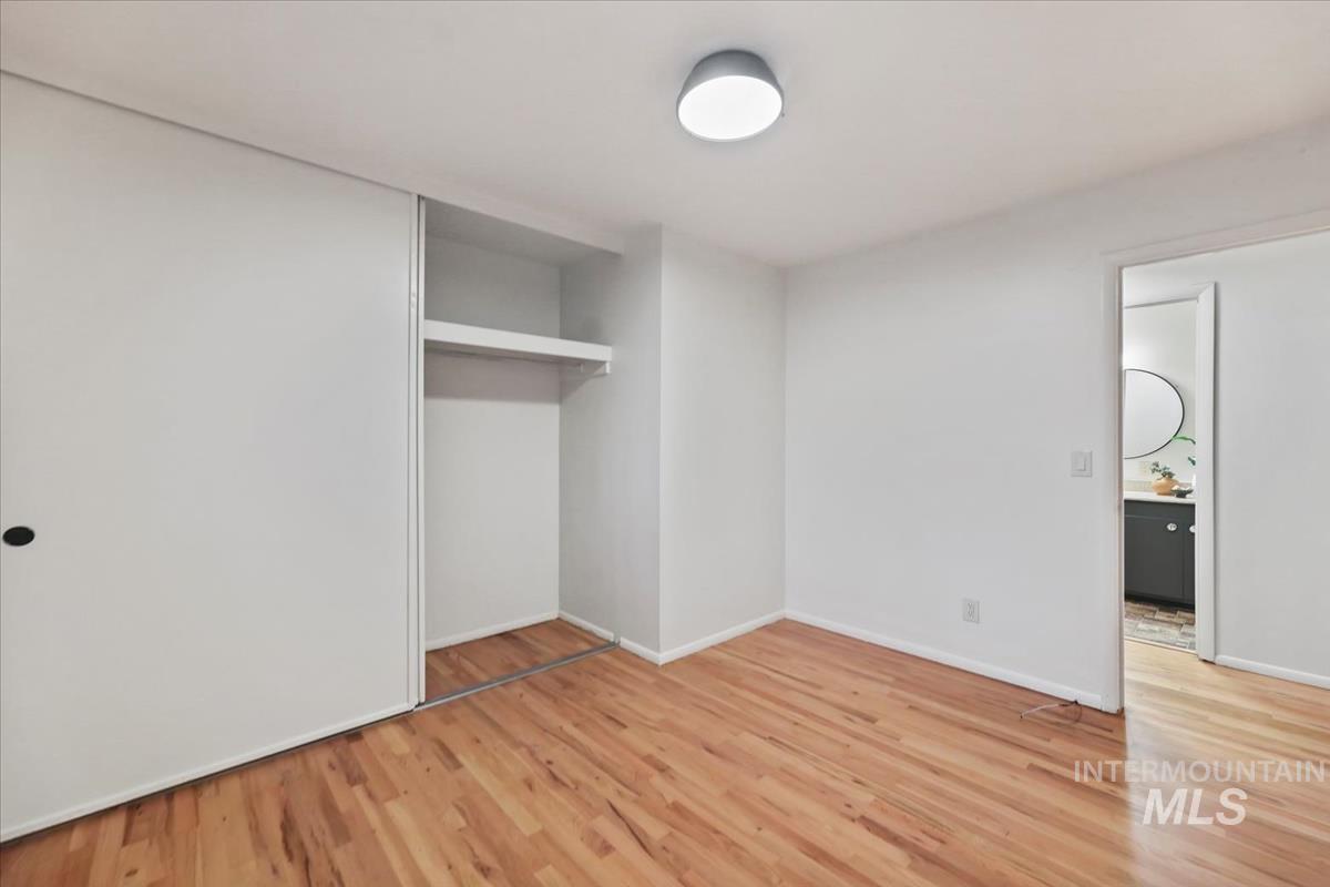 Unfurnished bedroom featuring light wood-type flooring and a closet