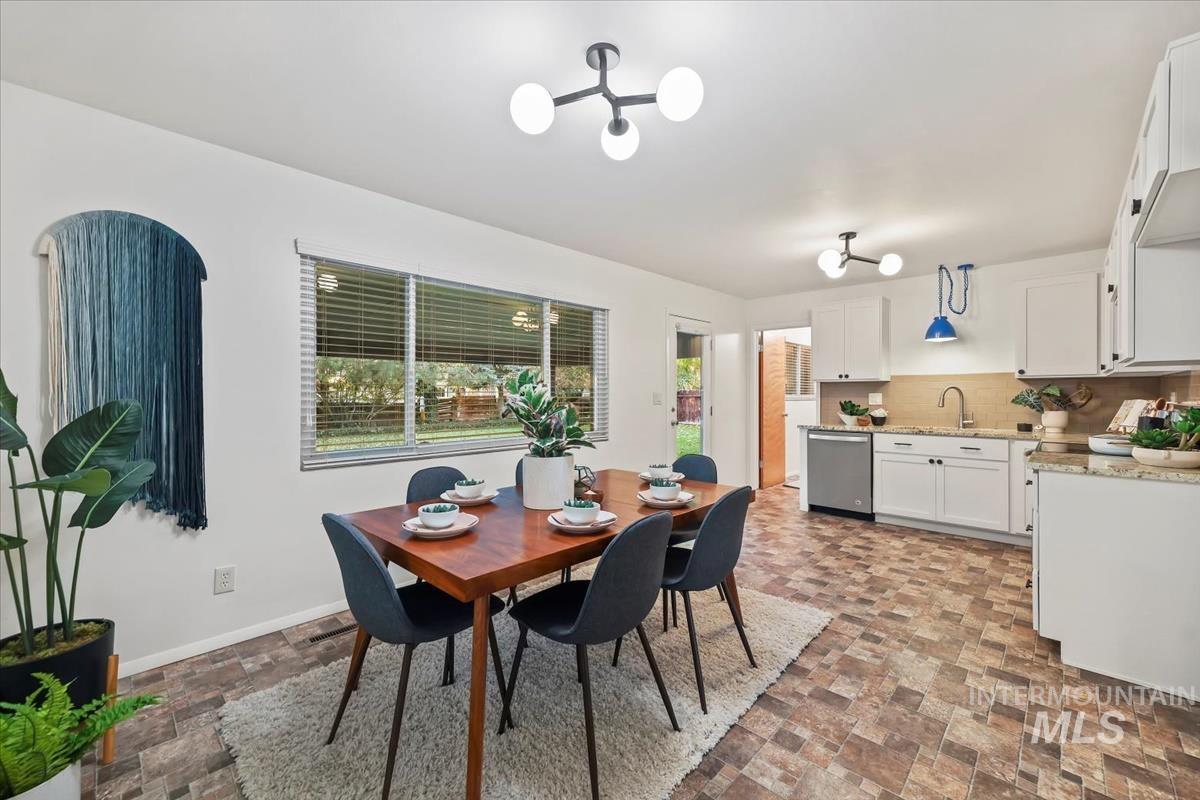 Dining room featuring dark stone finish flooring and baseboards