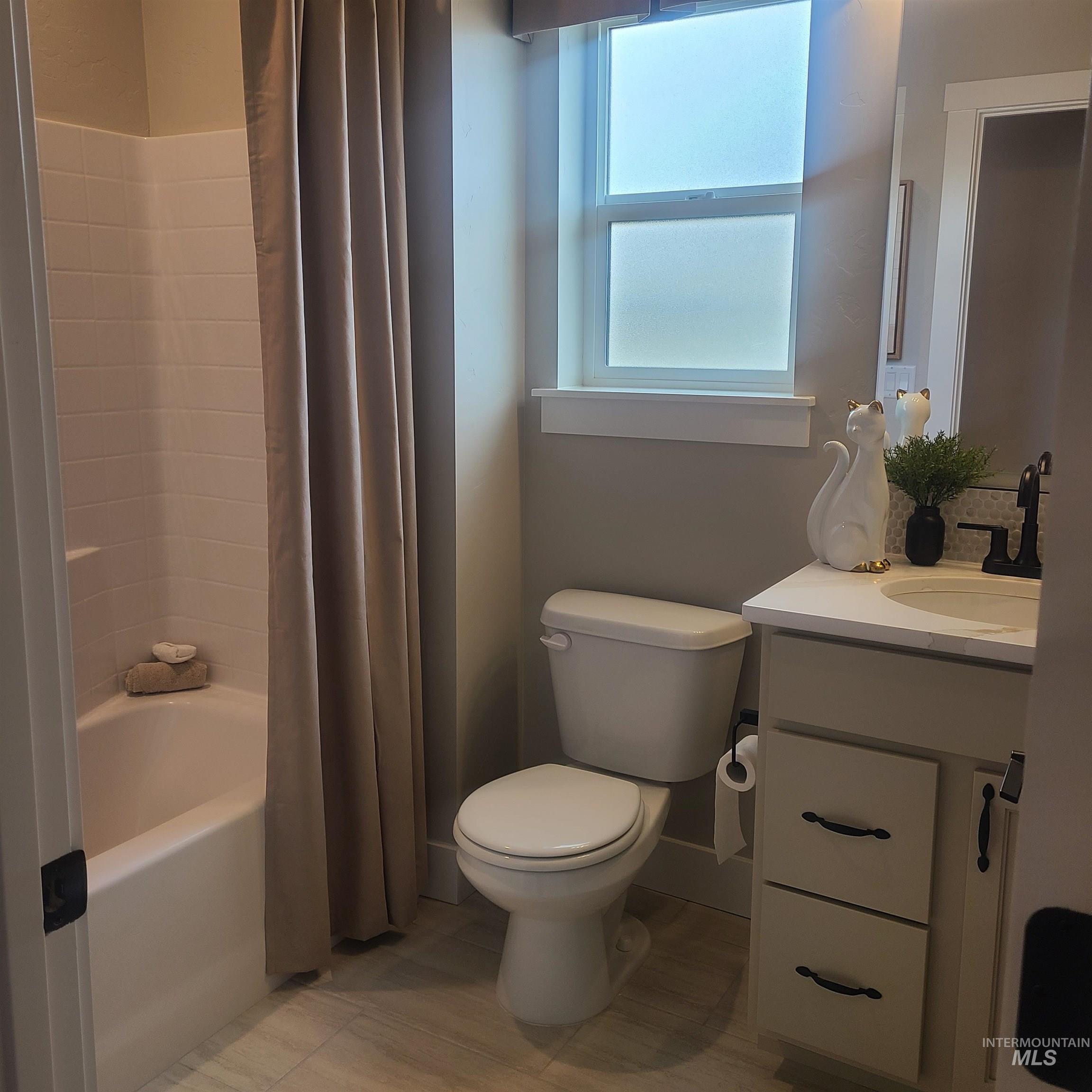 Full bathroom featuring vanity and shower / bath combination with curtain