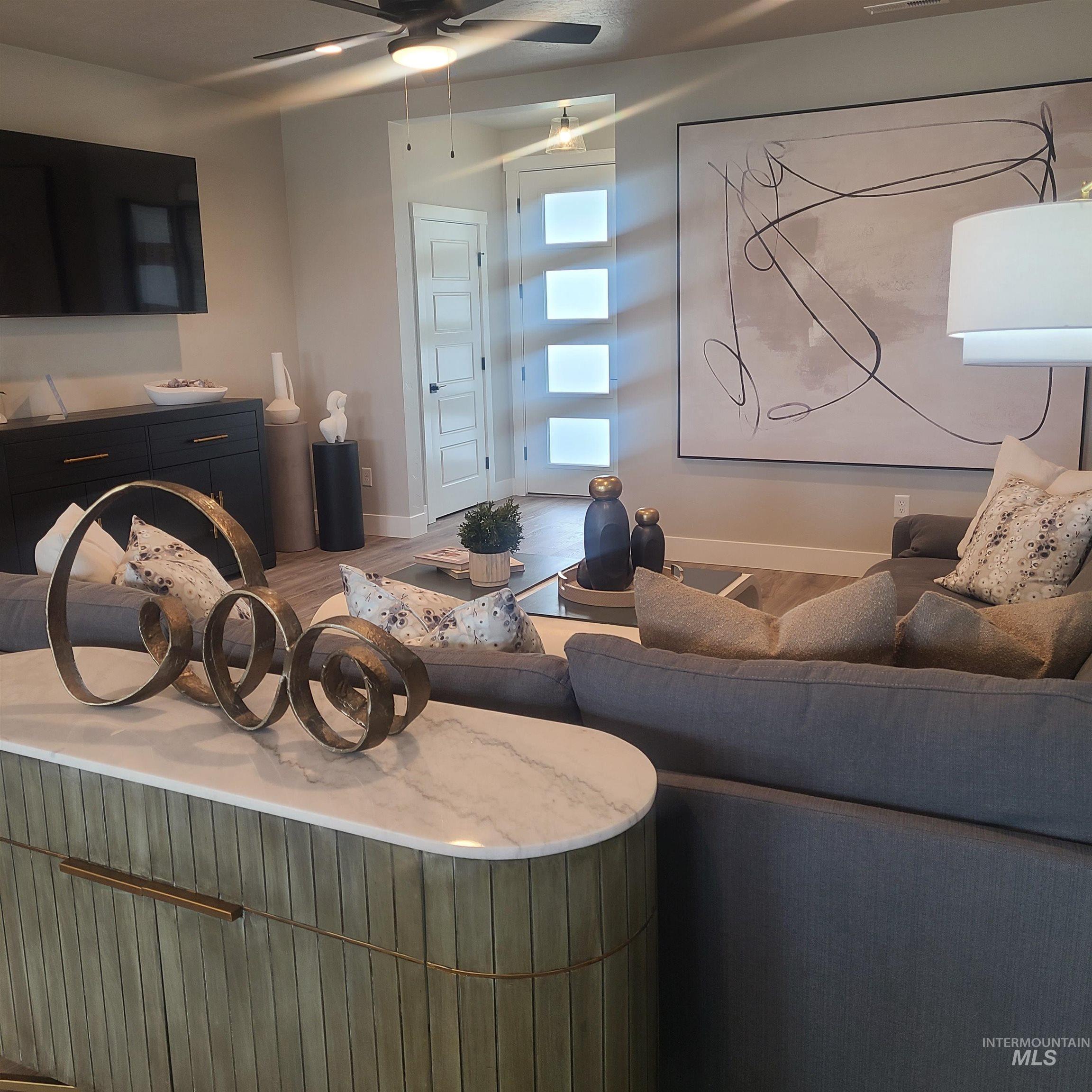 Living area with wood finished floors and ceiling fan