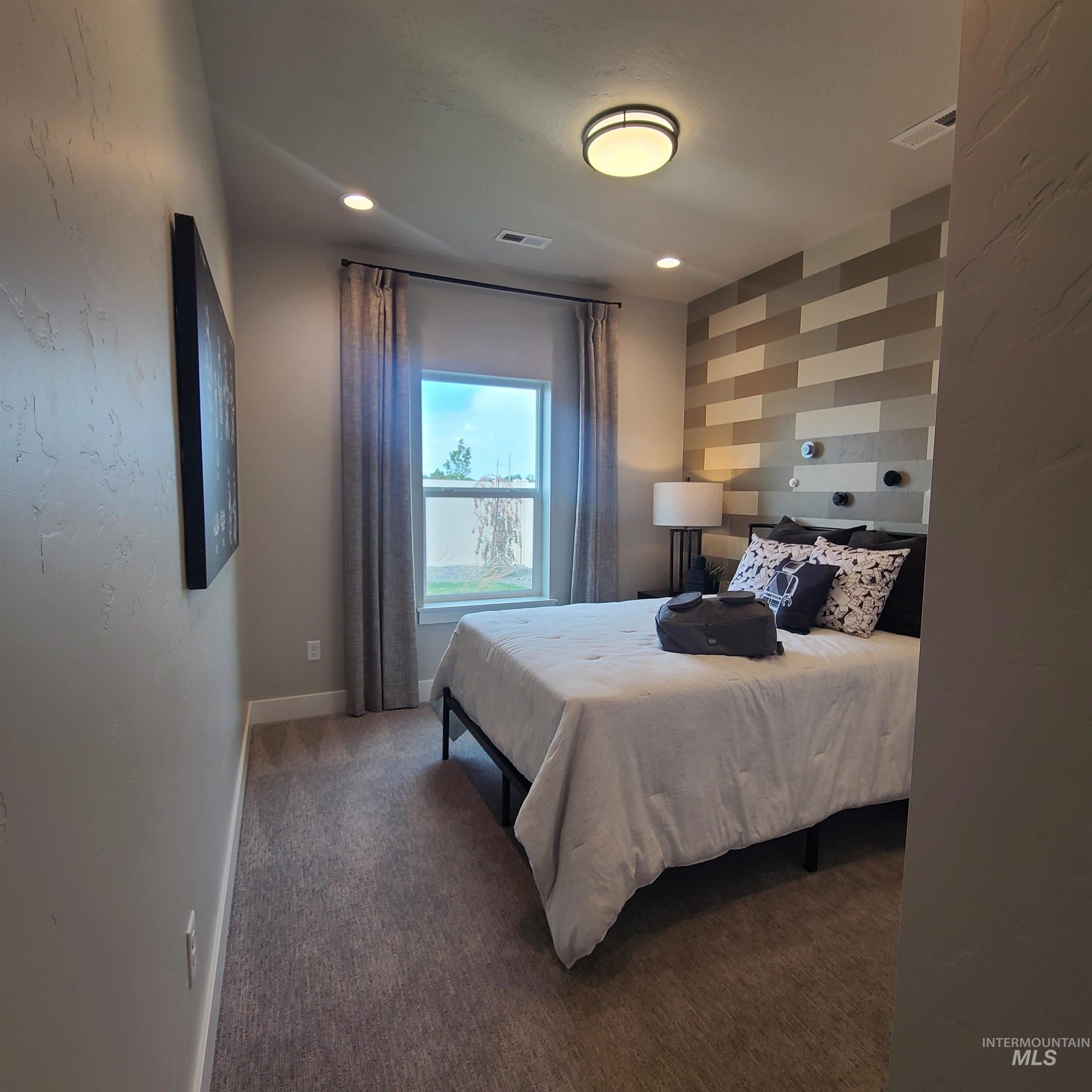 Bedroom featuring carpet flooring, an accent wall, and recessed lighting