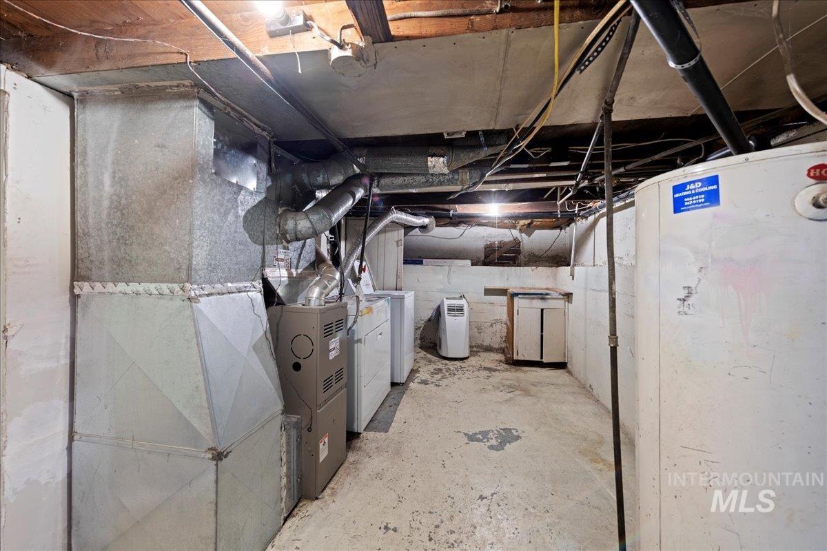 Unfinished basement featuring heating unit and washing machine and clothes dryer