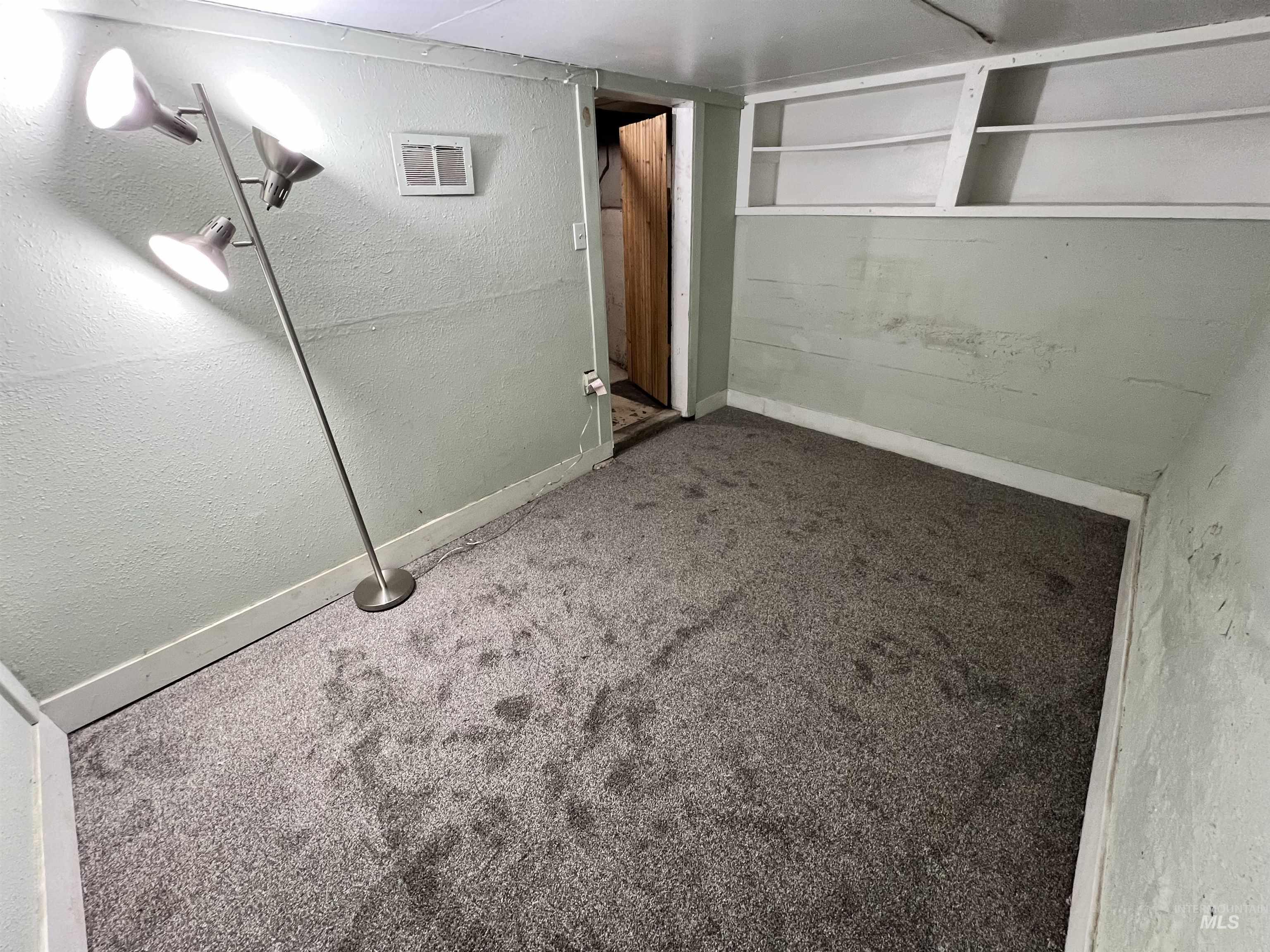 Below grade area with a textured wall and carpet flooring
