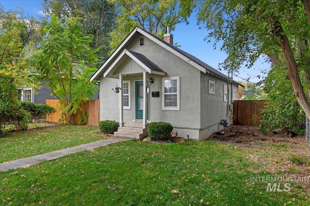 Bungalow-style home featuring a chimney and stucco siding