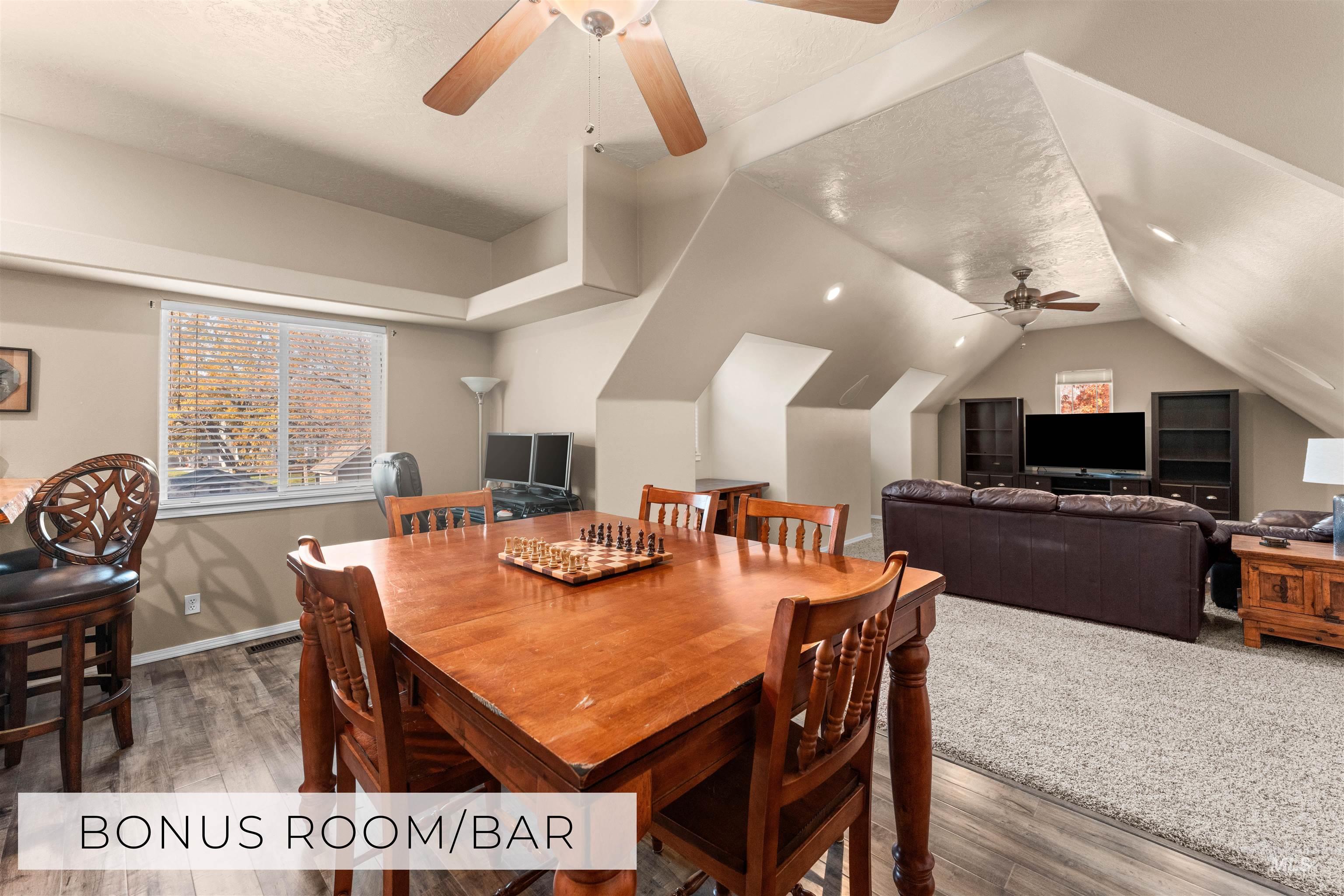 Dining space featuring plenty of natural light, a textured ceiling, wood finished floors, lofted ceiling, and a ceiling fan