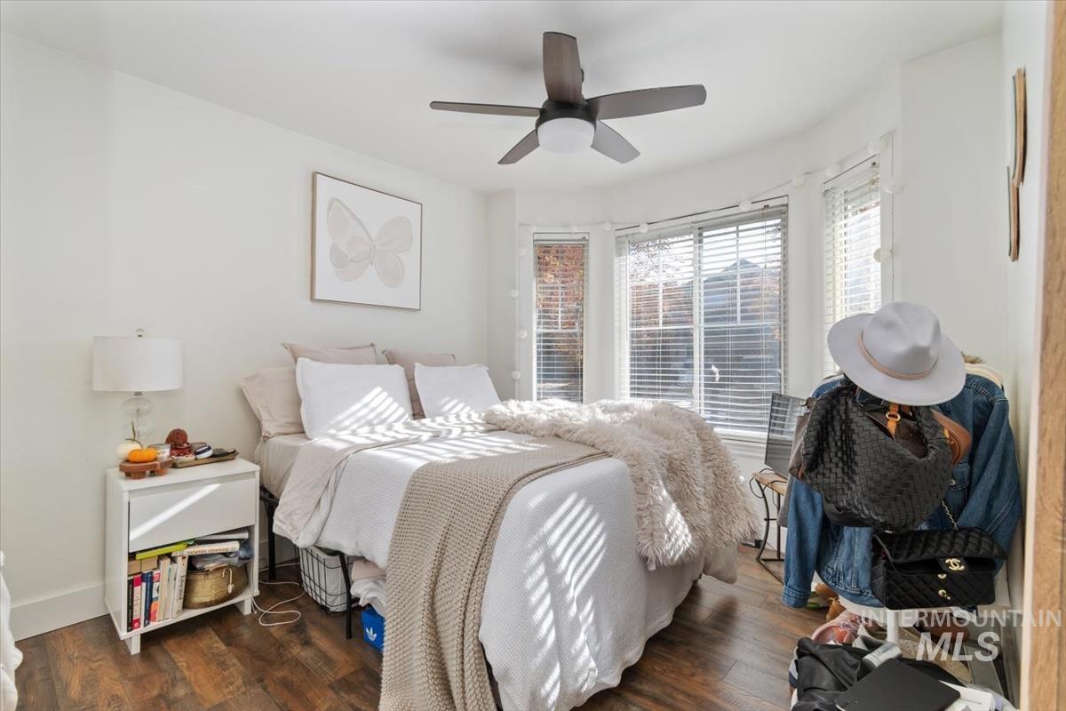 Bedroom with dark wood-style flooring and a ceiling fan