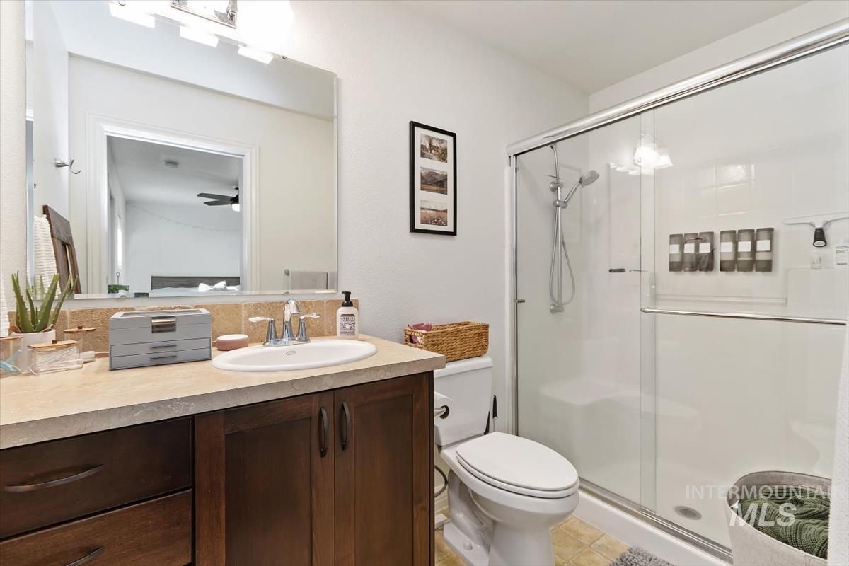 Bathroom with vanity, a stall shower, and light tile patterned flooring