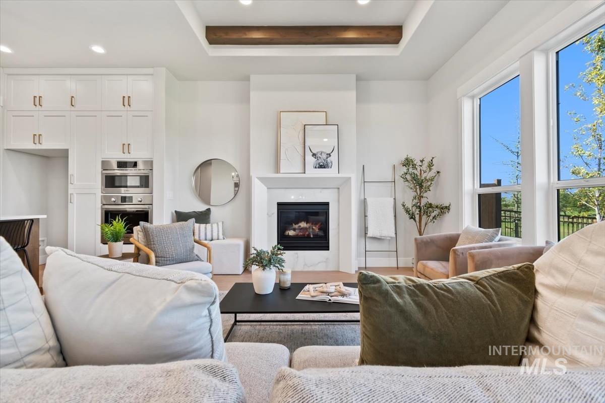 Living room featuring recessed lighting, a fireplace, and a tray ceiling