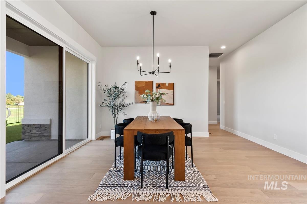 Dining space featuring a chandelier, light wood-style flooring, and recessed lighting