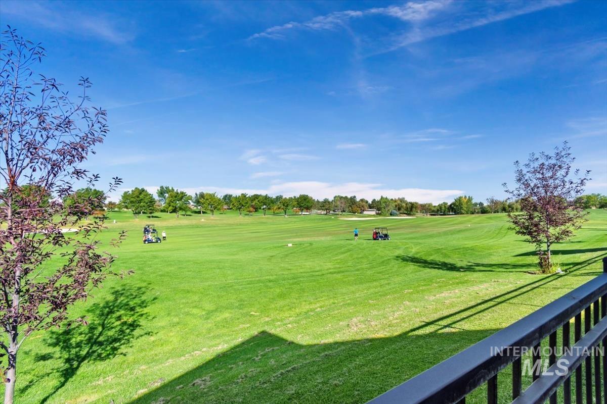 Surrounding community with golf course view and a lawn