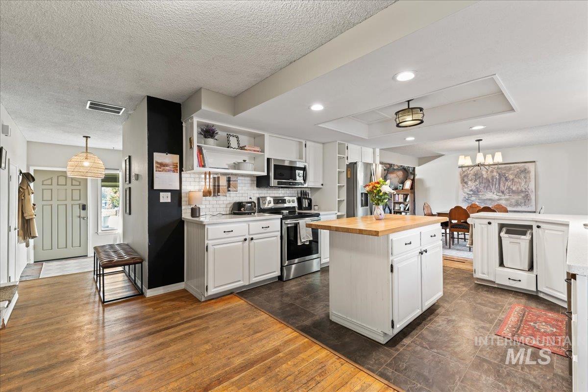 Kitchen with pendant lighting, open shelves, stainless steel appliances, white cabinetry, and recessed lighting