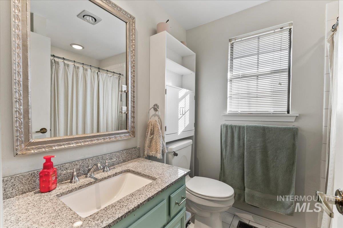 Full bath featuring vanity and curtained shower