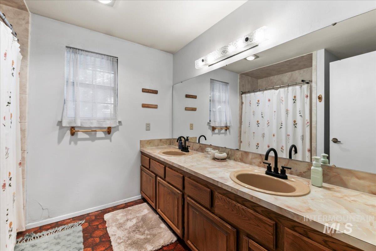 Full bathroom with double vanity and a shower with curtain