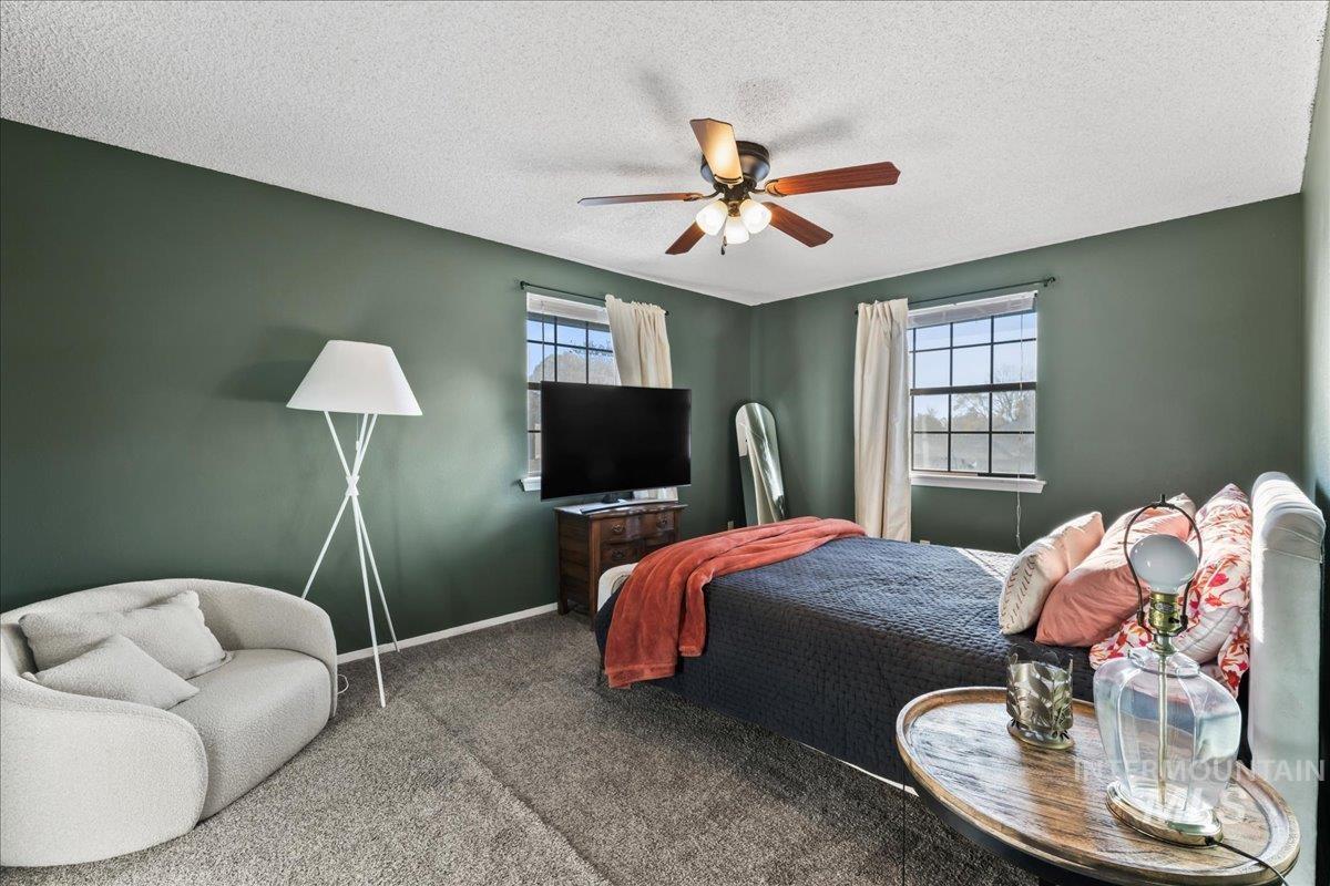 Bedroom featuring carpet flooring, ceiling fan, and a textured ceiling