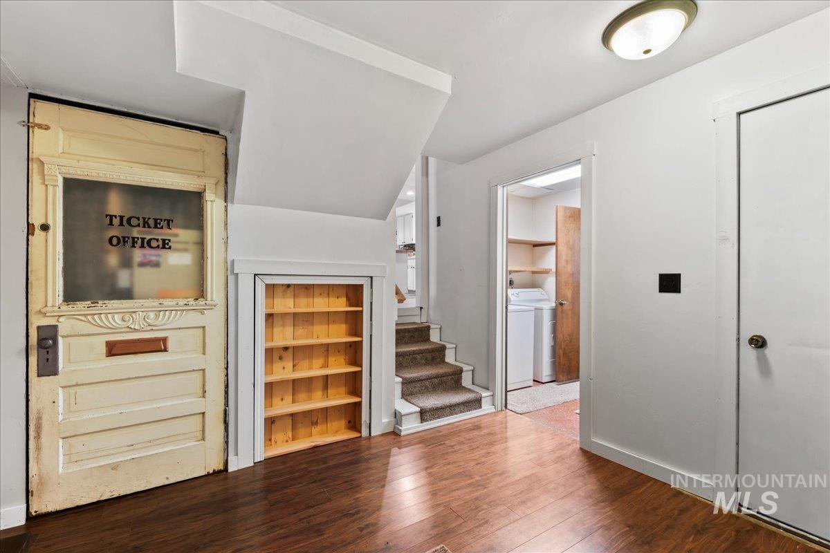 Entryway with wood finished floors, washer / dryer, and stairway