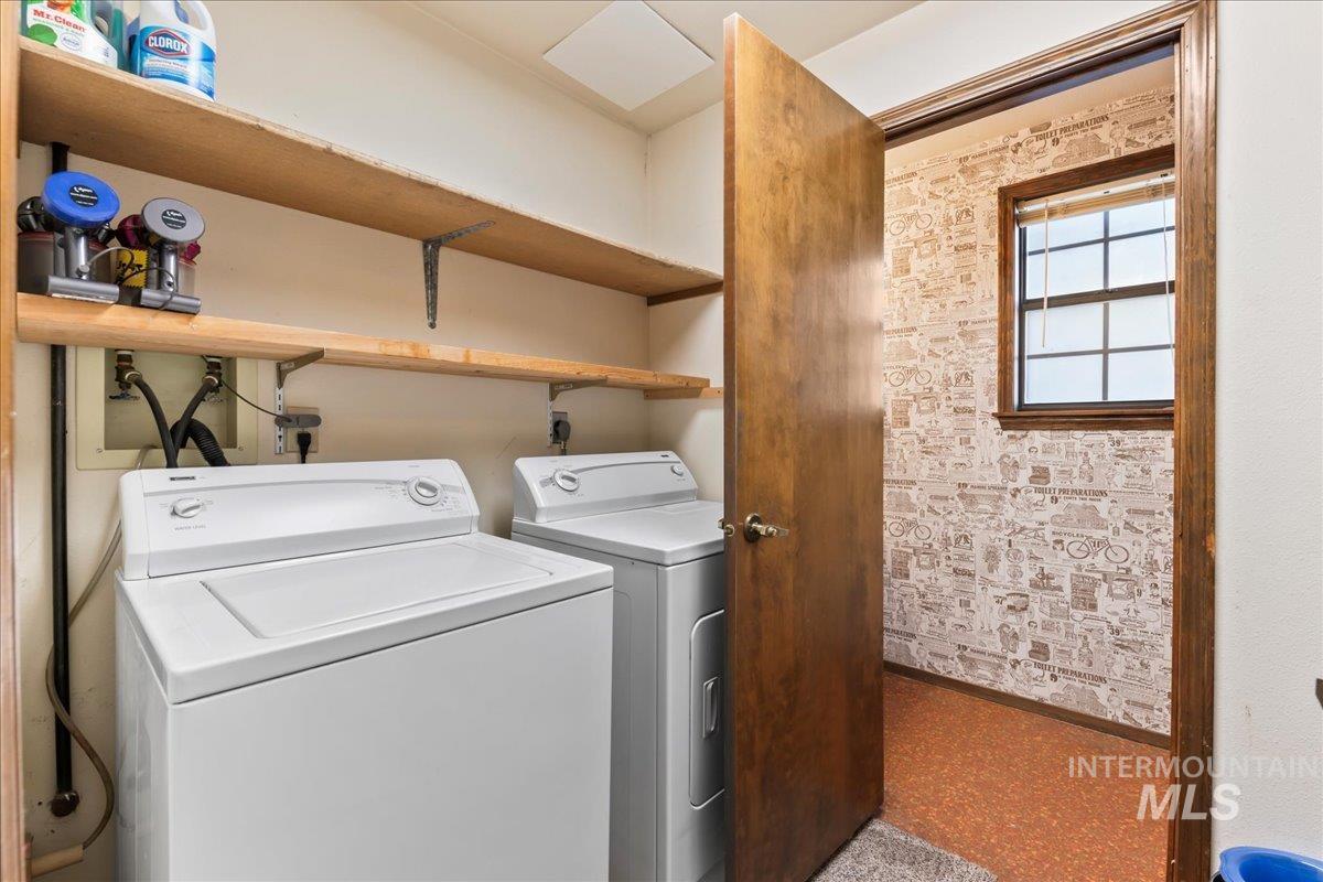 Laundry area featuring separate washer and dryer and baseboards