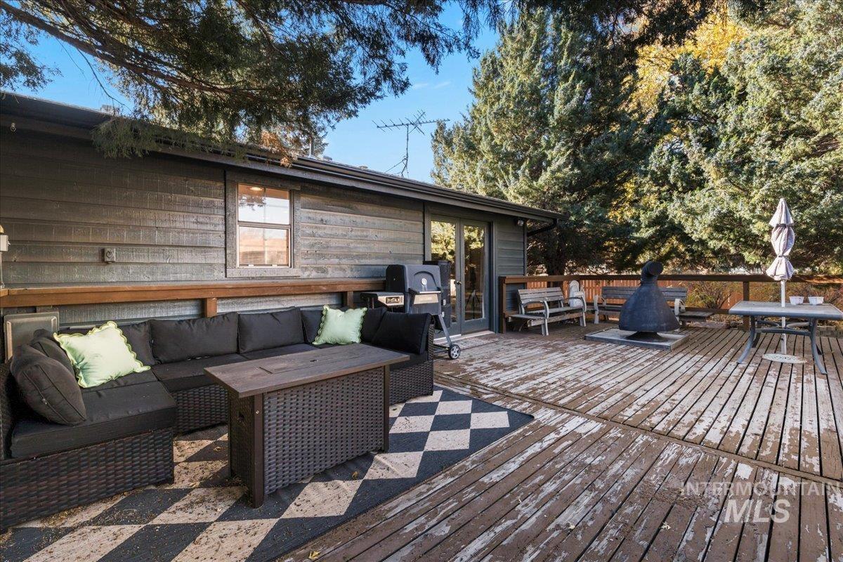 Wooden terrace with an outdoor hangout area and area for grilling