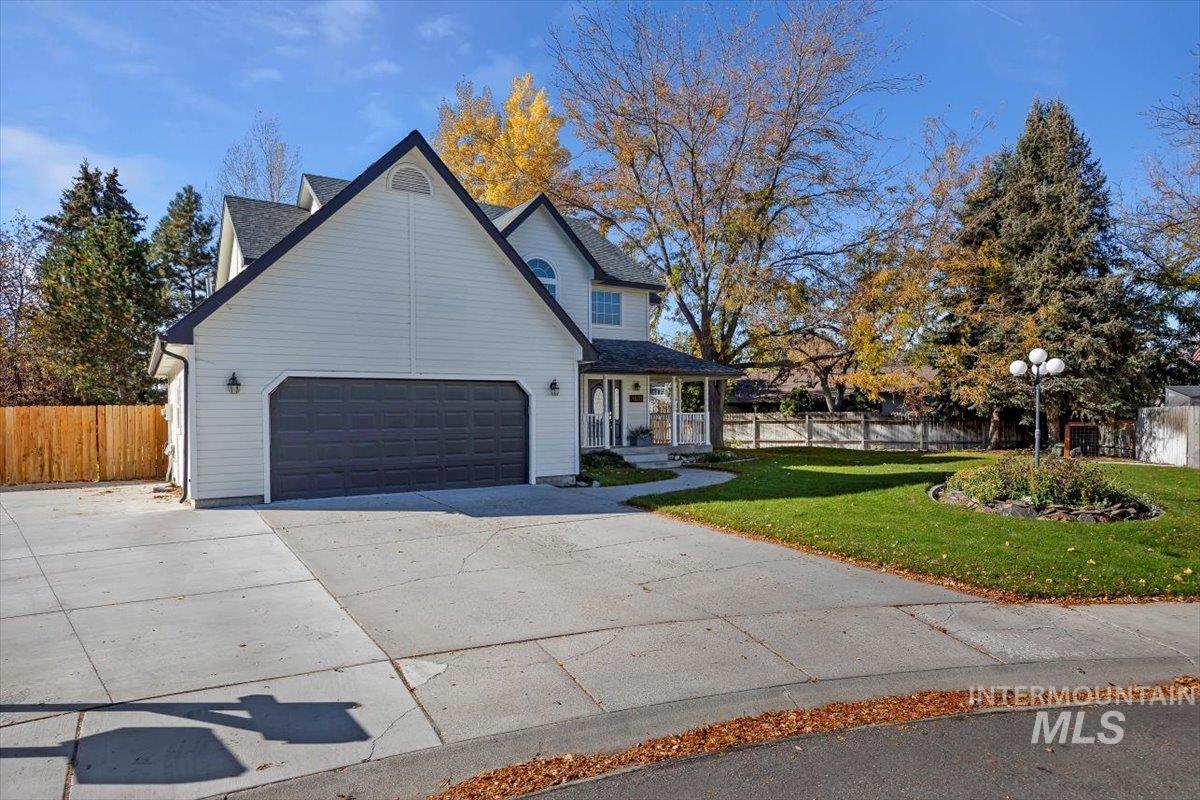 View of side of property with driveway, covered porch, and an attached garage