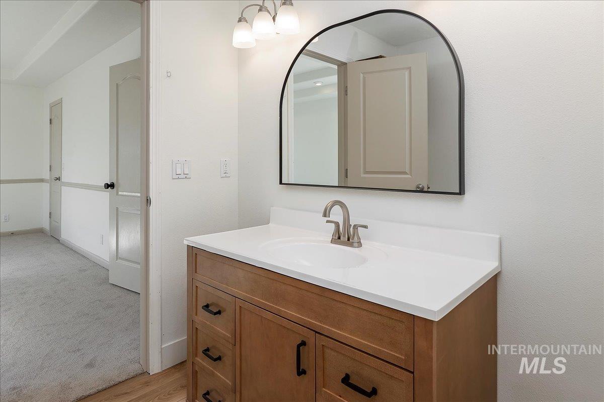Bathroom featuring vanity, light carpet, and light wood-style floors