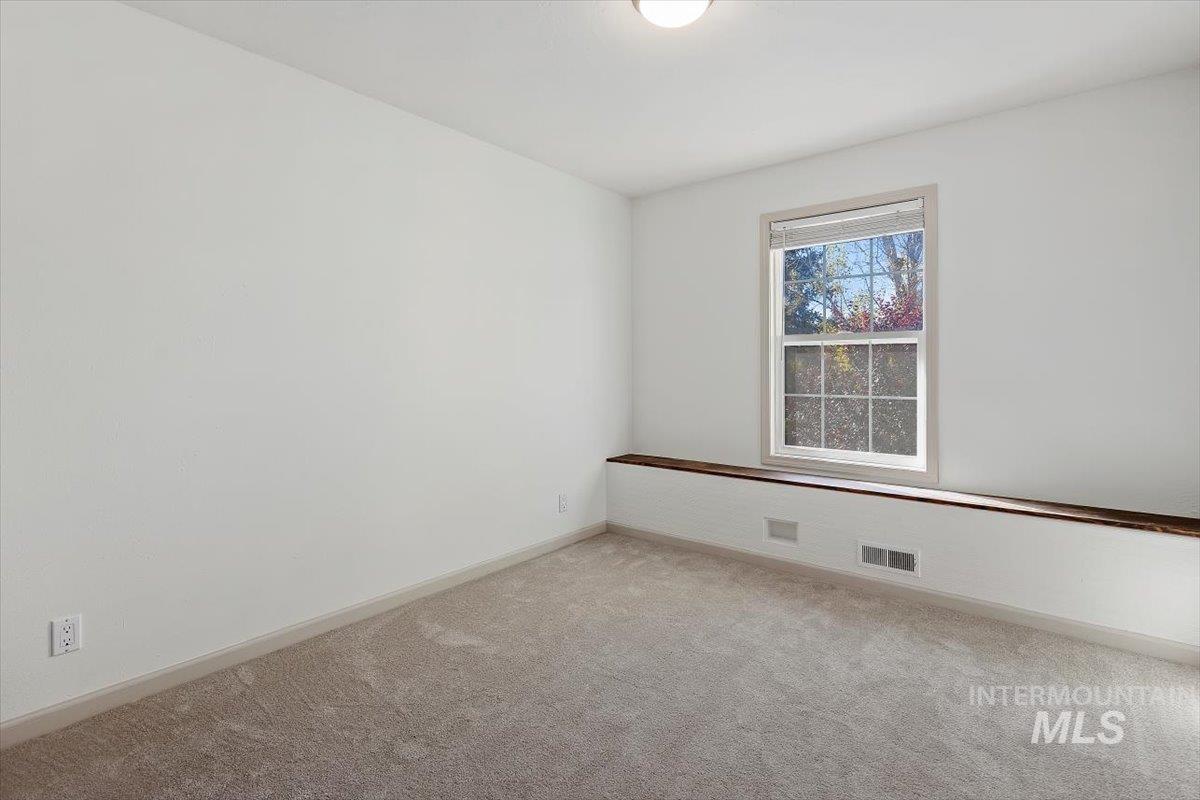 Carpeted empty room with baseboards