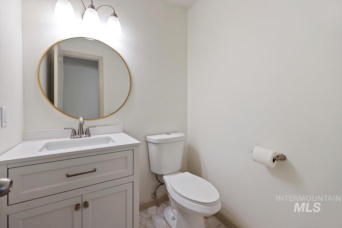 Half bathroom featuring vanity and toilet