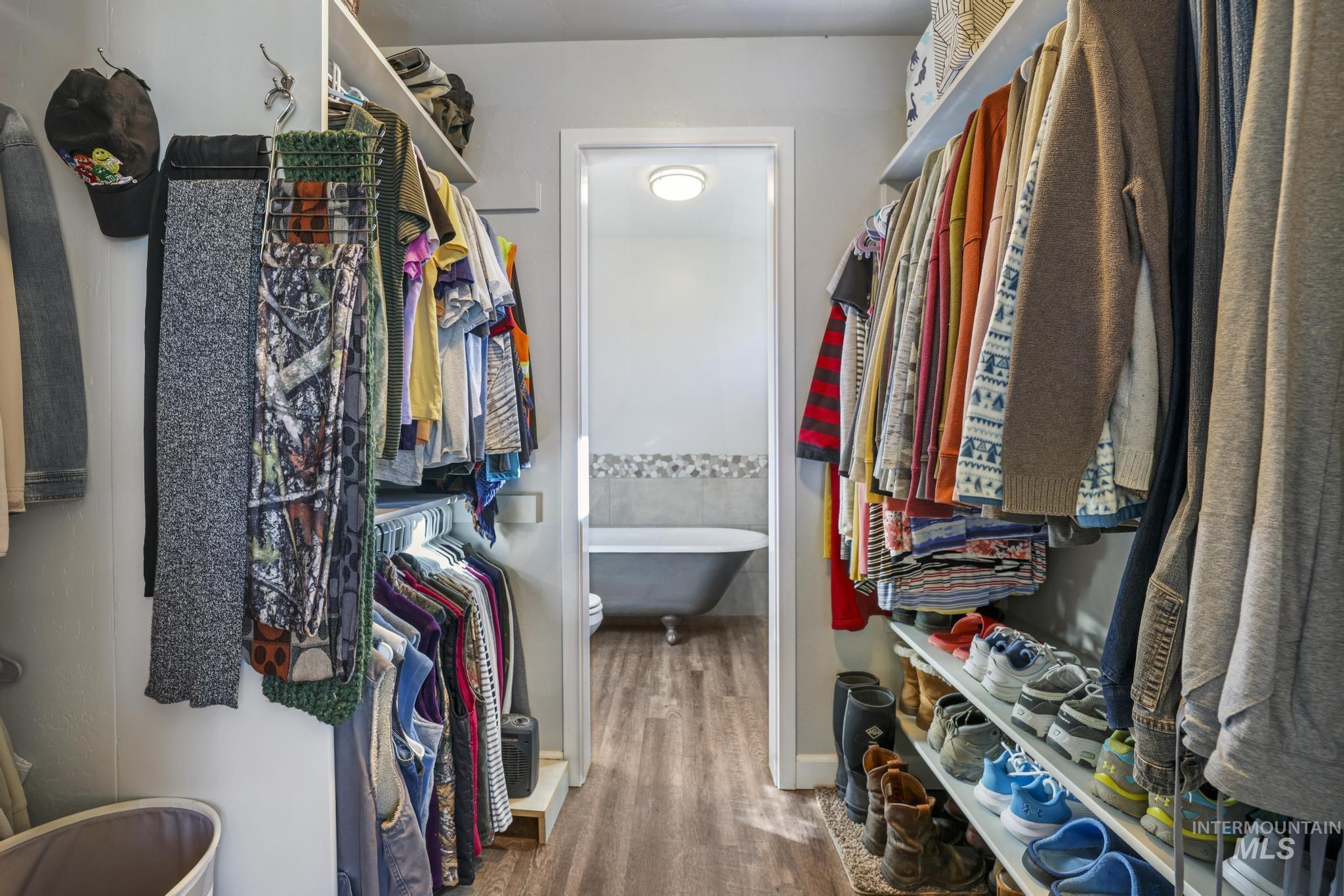 Spacious closet with dark wood-style floors