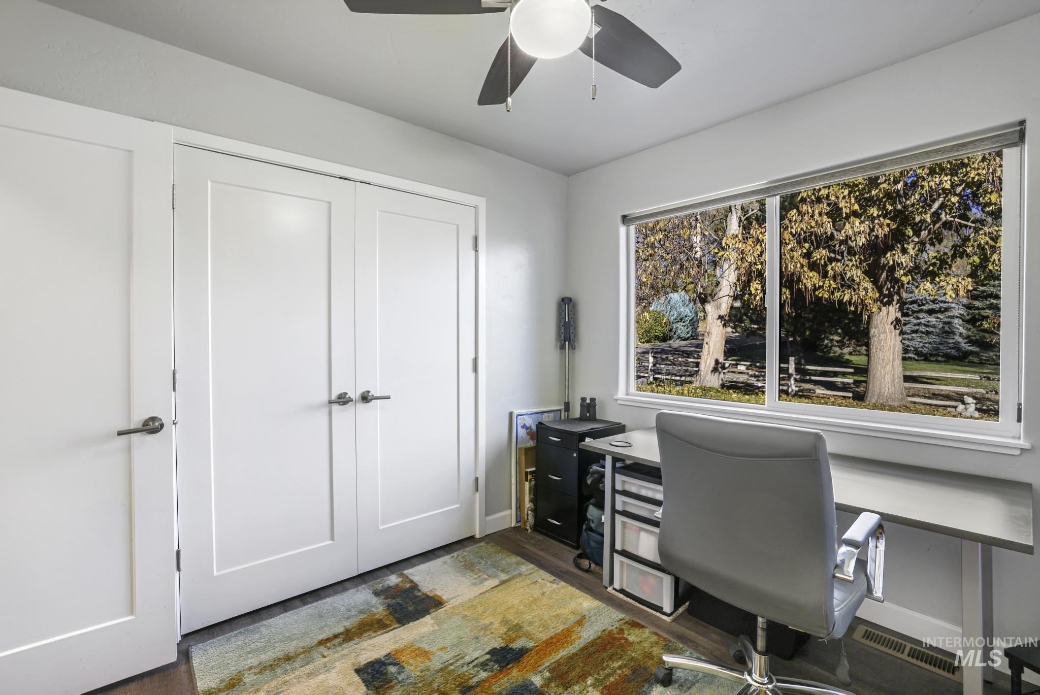 Office area with wood finished floors and a ceiling fan