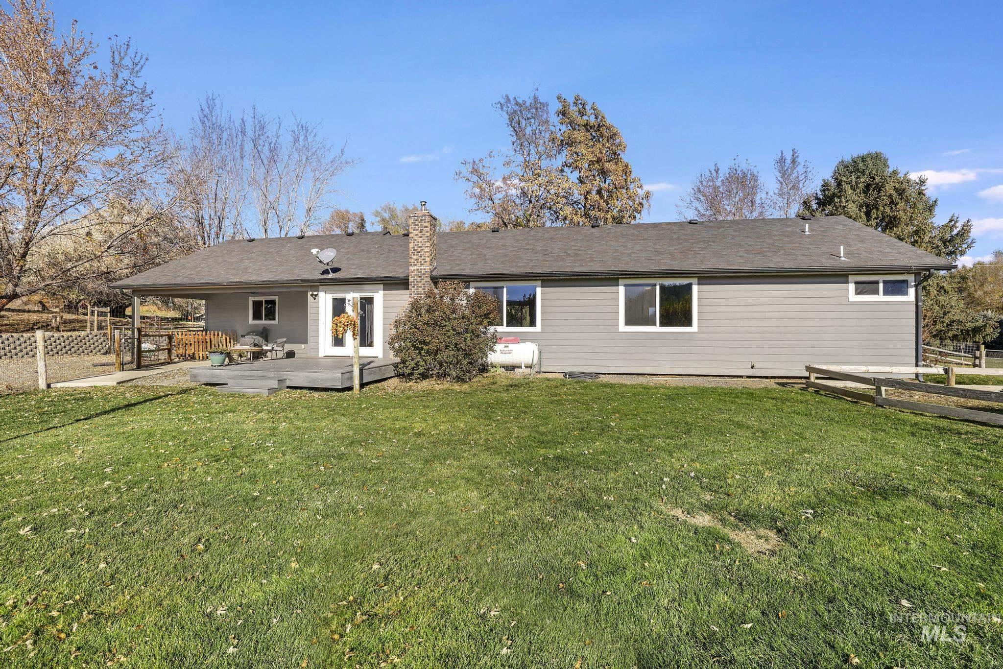Back of house featuring a chimney and a wooden deck