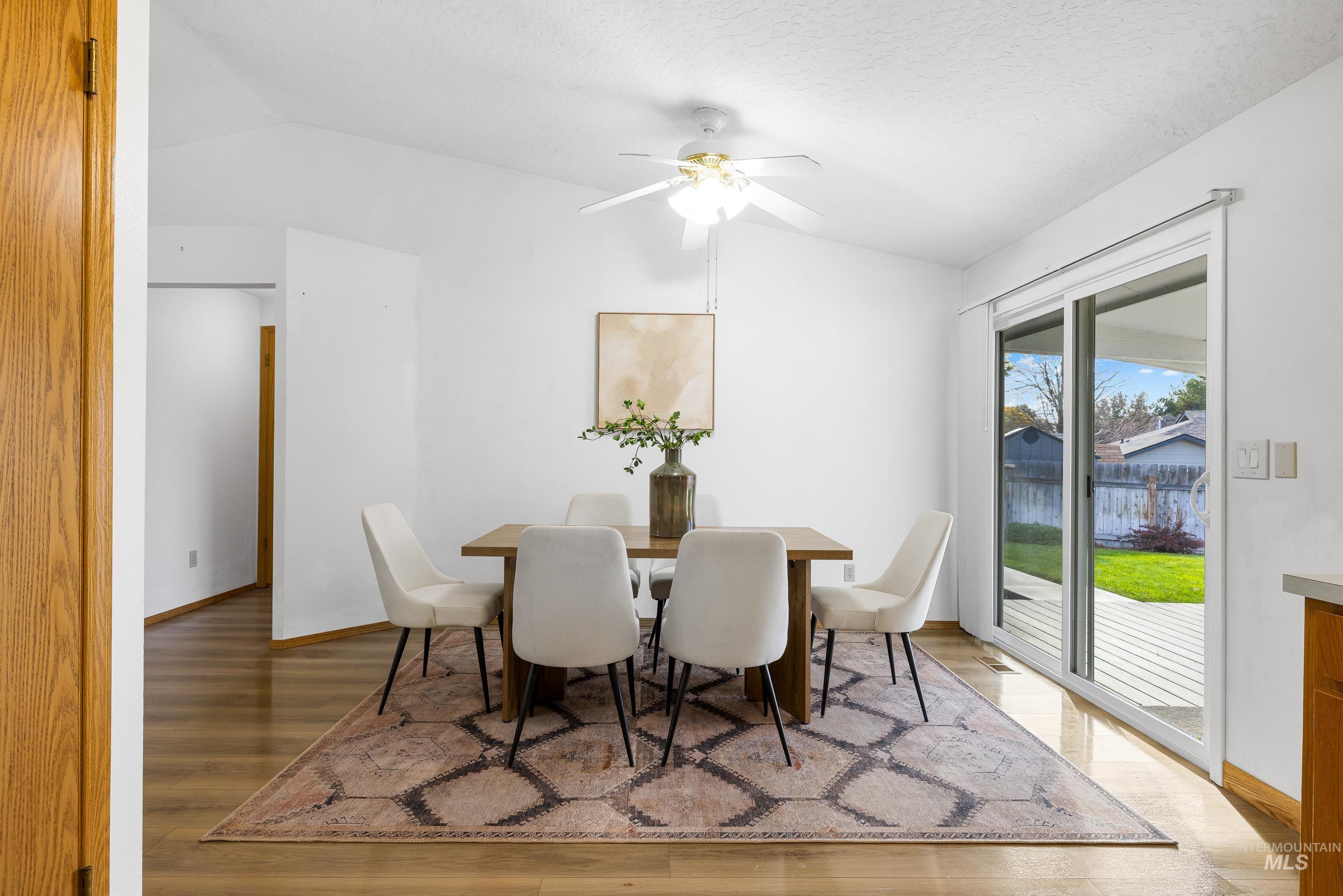Dining room featuring lofted ceiling, light wood-type flooring, and a ceiling fan