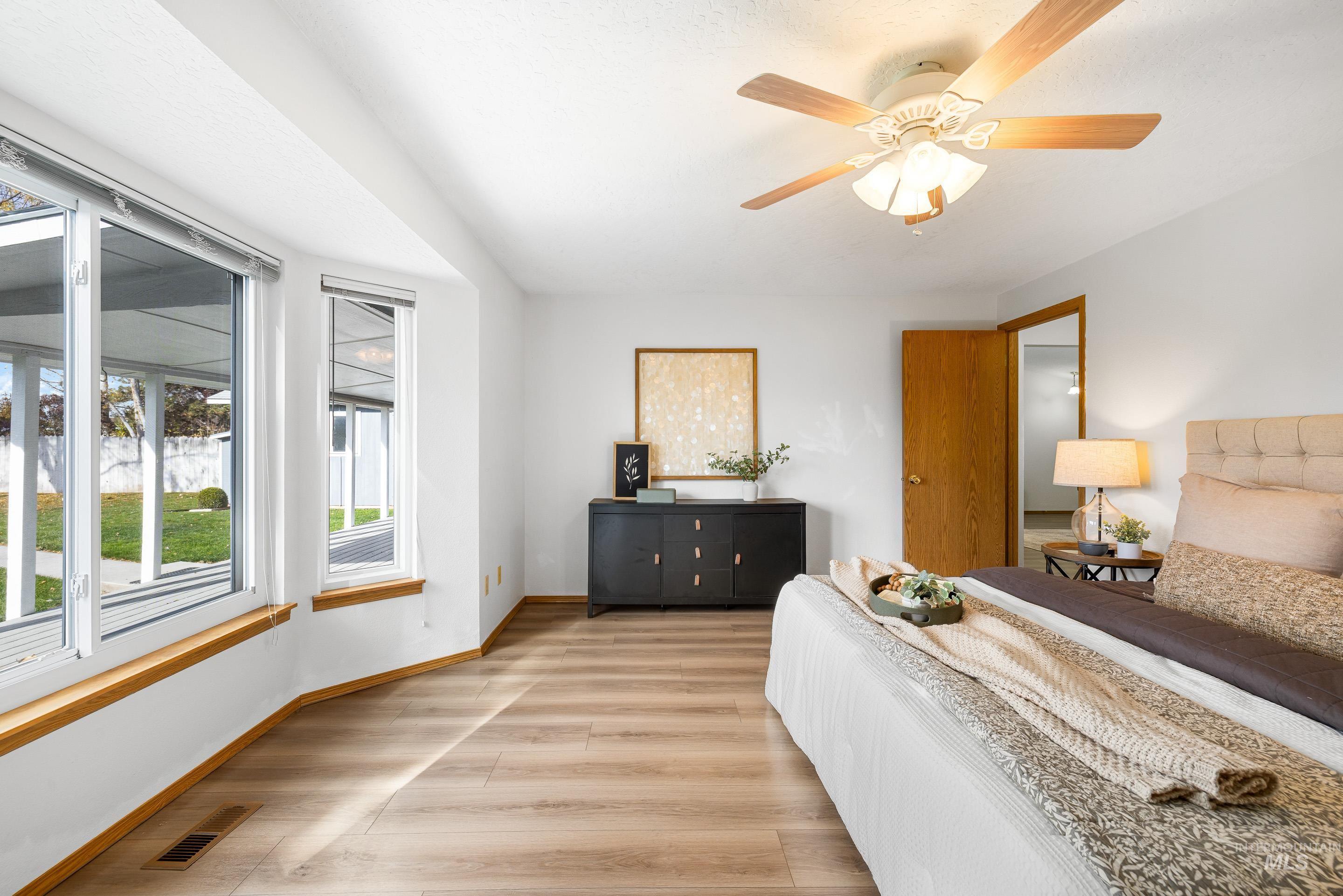 Bedroom with light wood finished floors and a ceiling fan