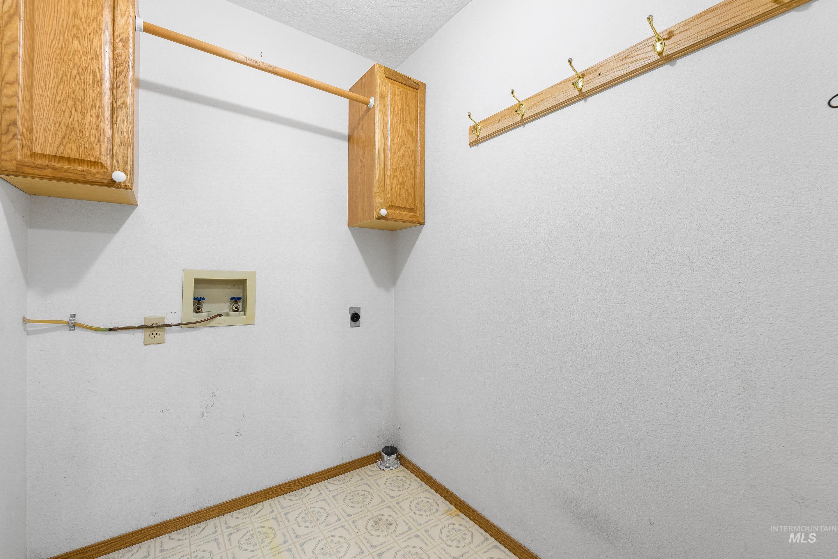 Laundry area with washer hookup, electric dryer hookup, and cabinet space