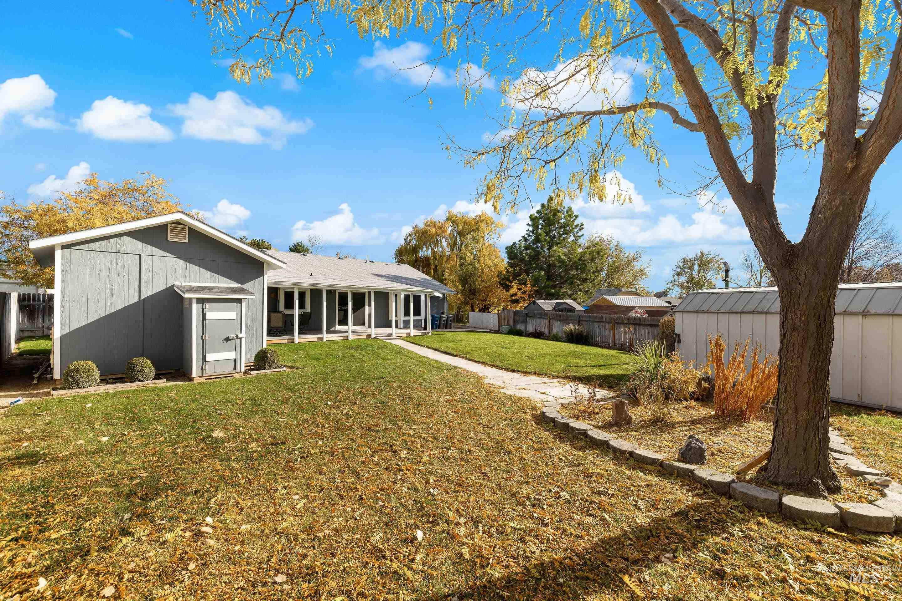 Back of house featuring a fenced backyard, an outdoor structure, and a sunroom