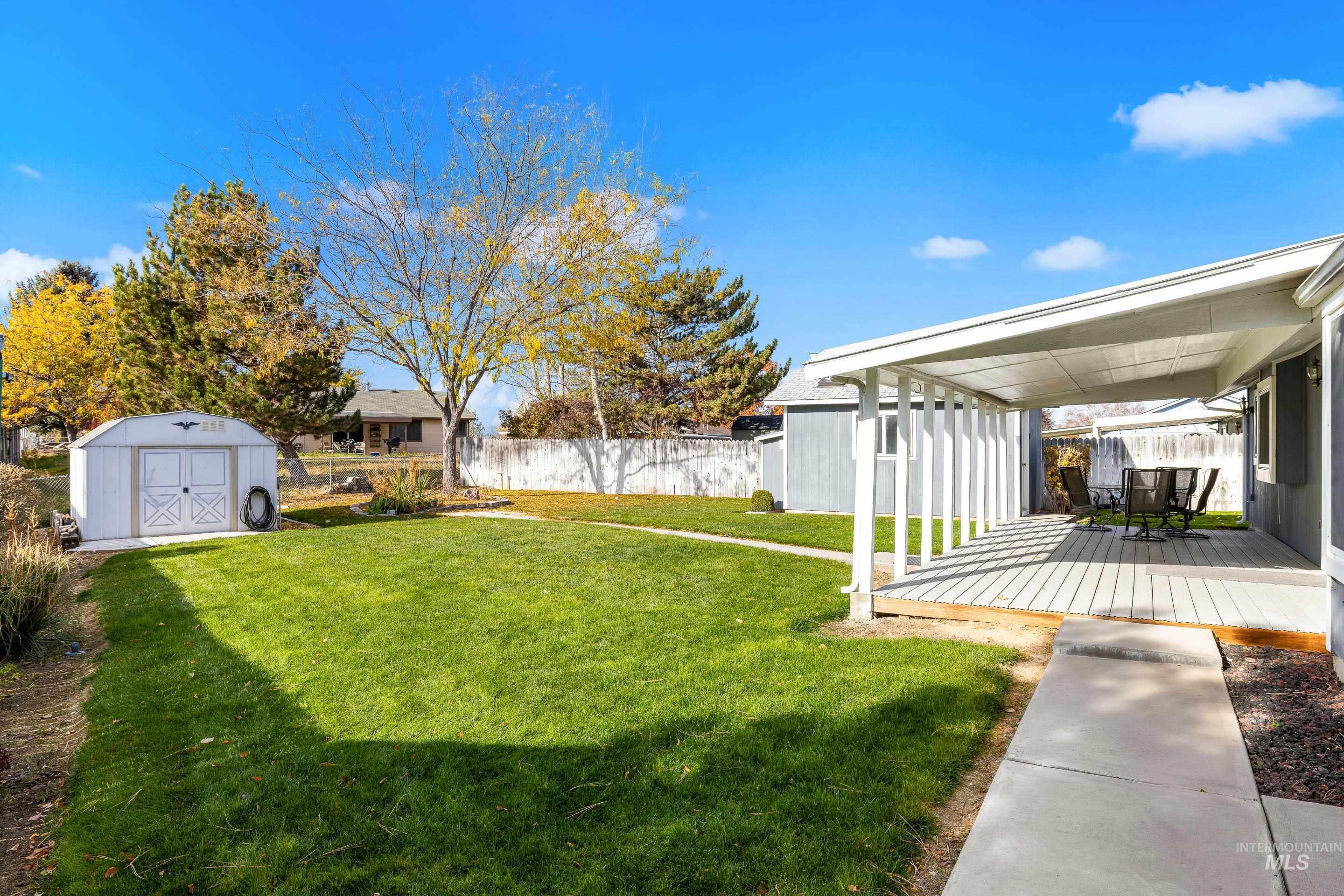 Fenced yard featuring a shed and a wooden deck