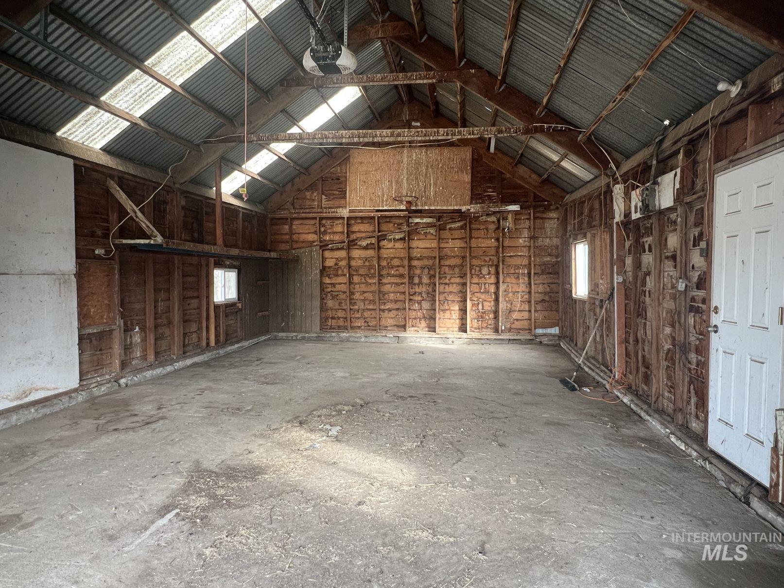 Misc room with high vaulted ceiling and a garage