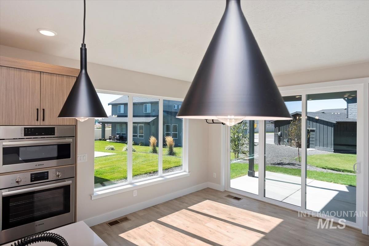 Unfurnished dining area with light wood-style flooring and baseboards