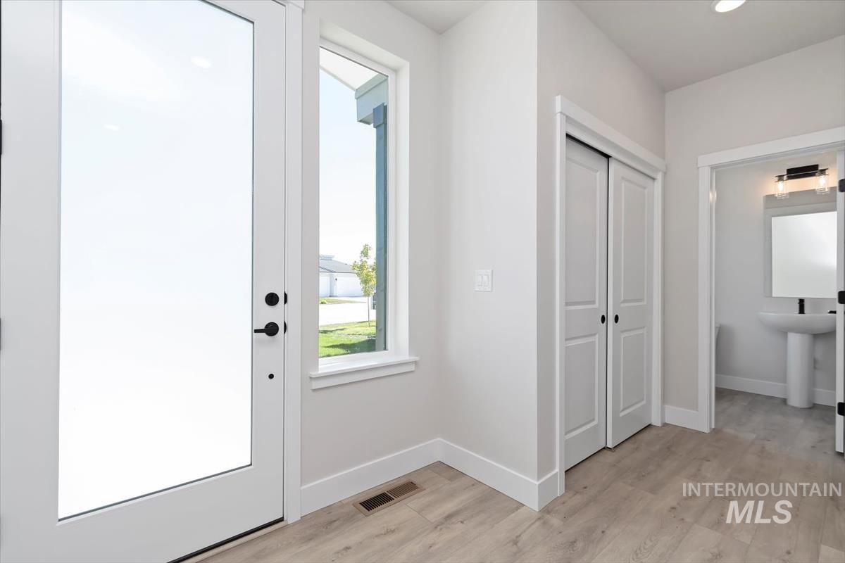 Doorway to outside with wood finished floors and recessed lighting