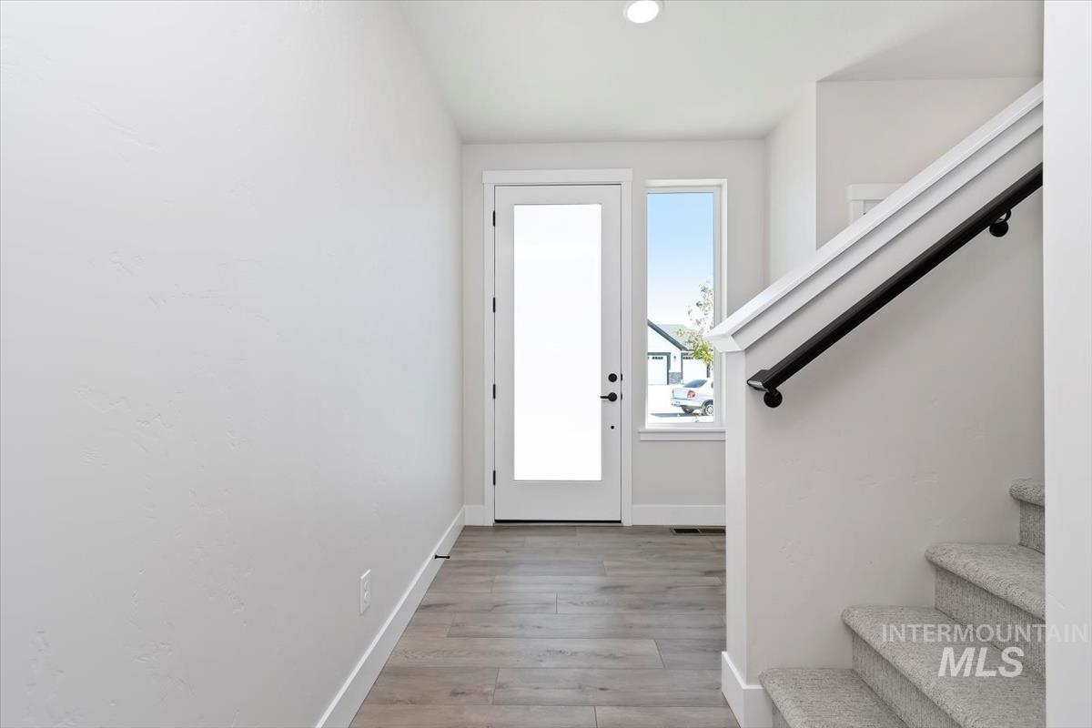 Foyer entrance featuring stairway, light wood finished floors, and recessed lighting