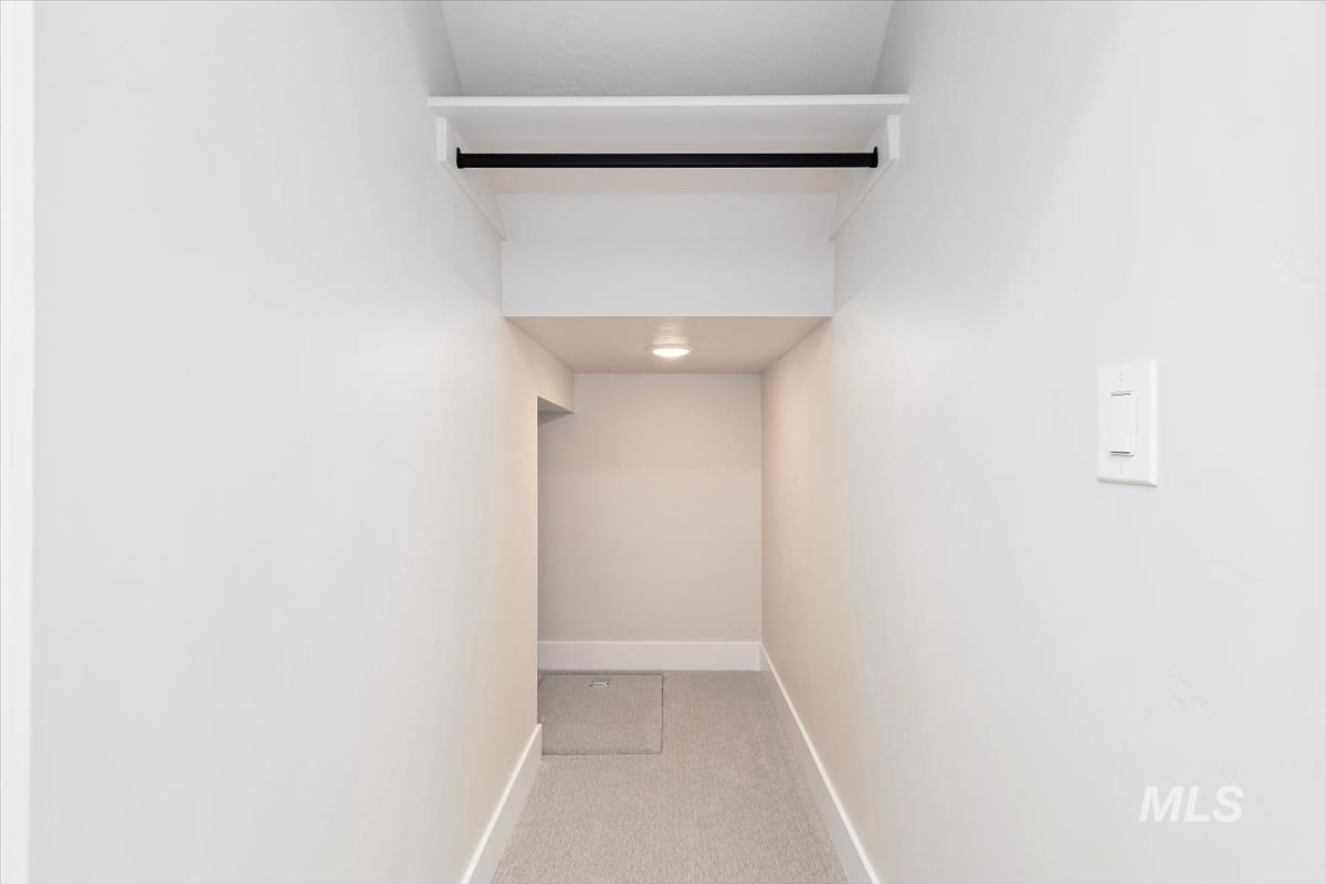 Hall with baseboards and light colored carpet