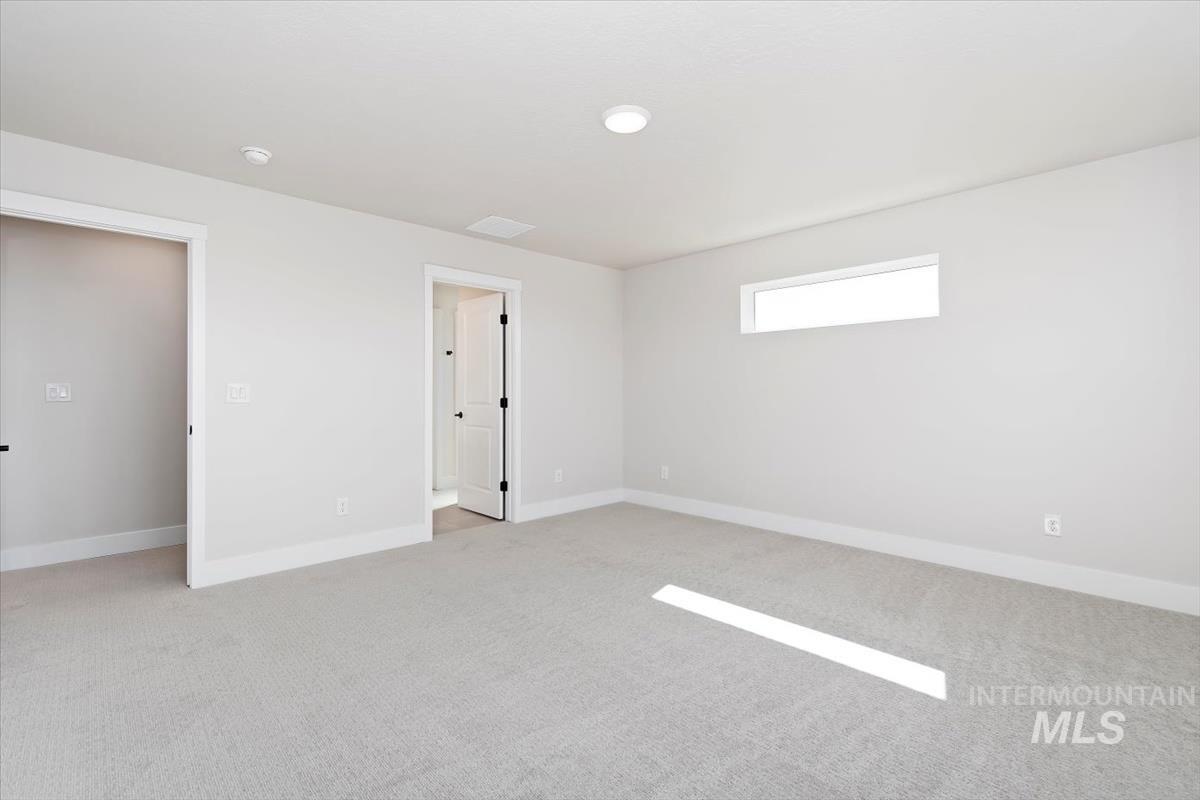 Empty room with light carpet and baseboards