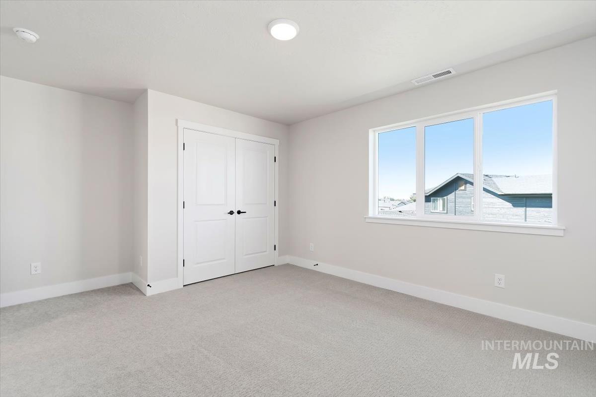 Unfurnished bedroom featuring light colored carpet and a closet