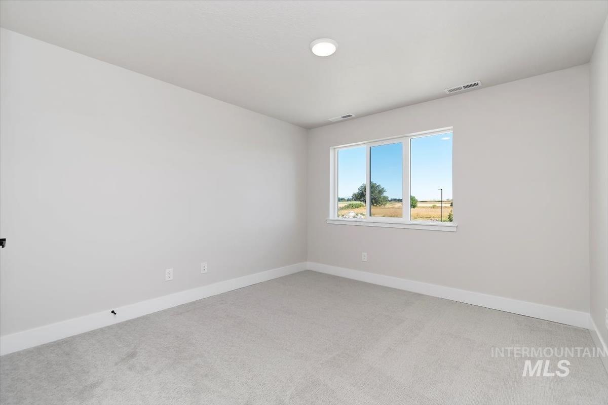 Unfurnished room with baseboards and light colored carpet