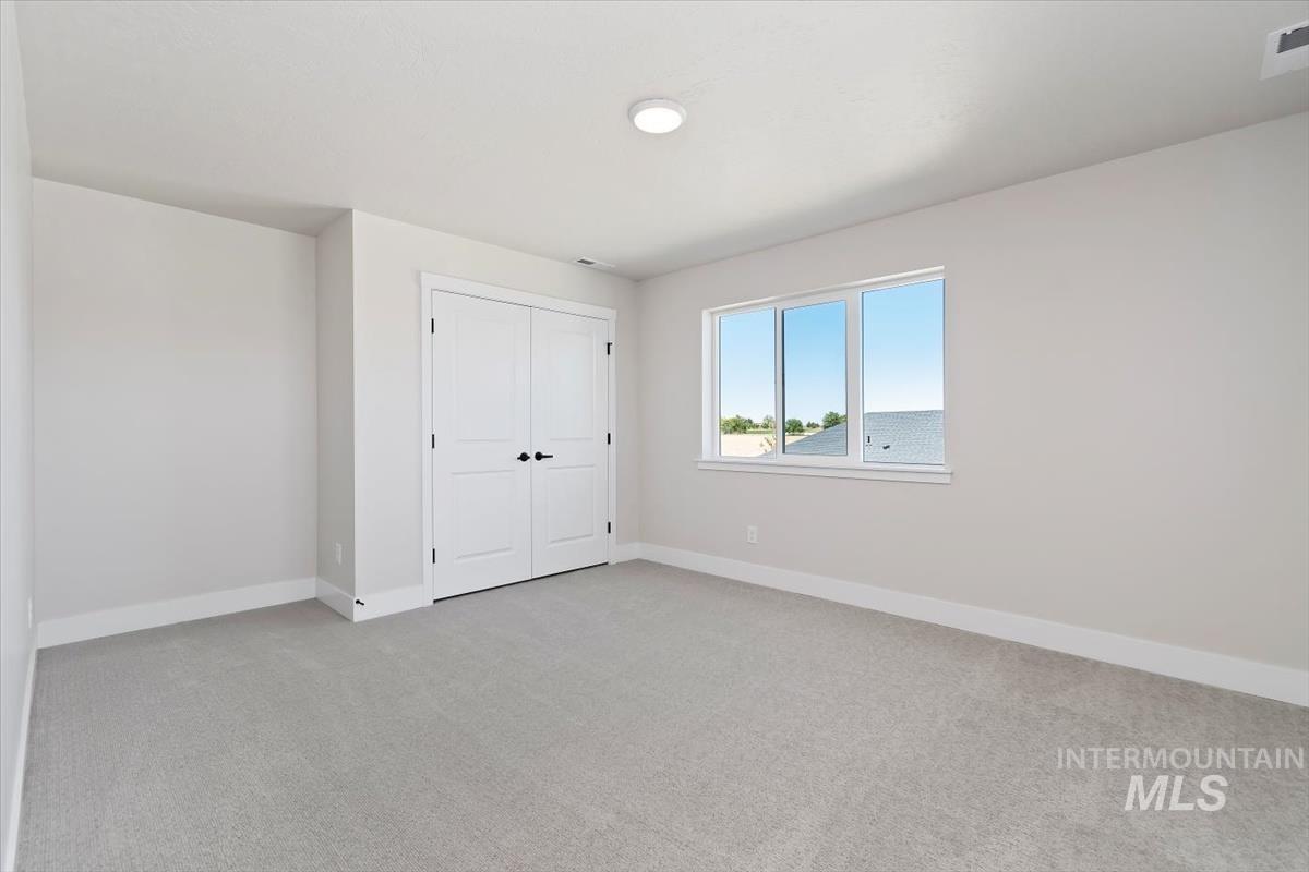 Unfurnished bedroom with light colored carpet and a closet
