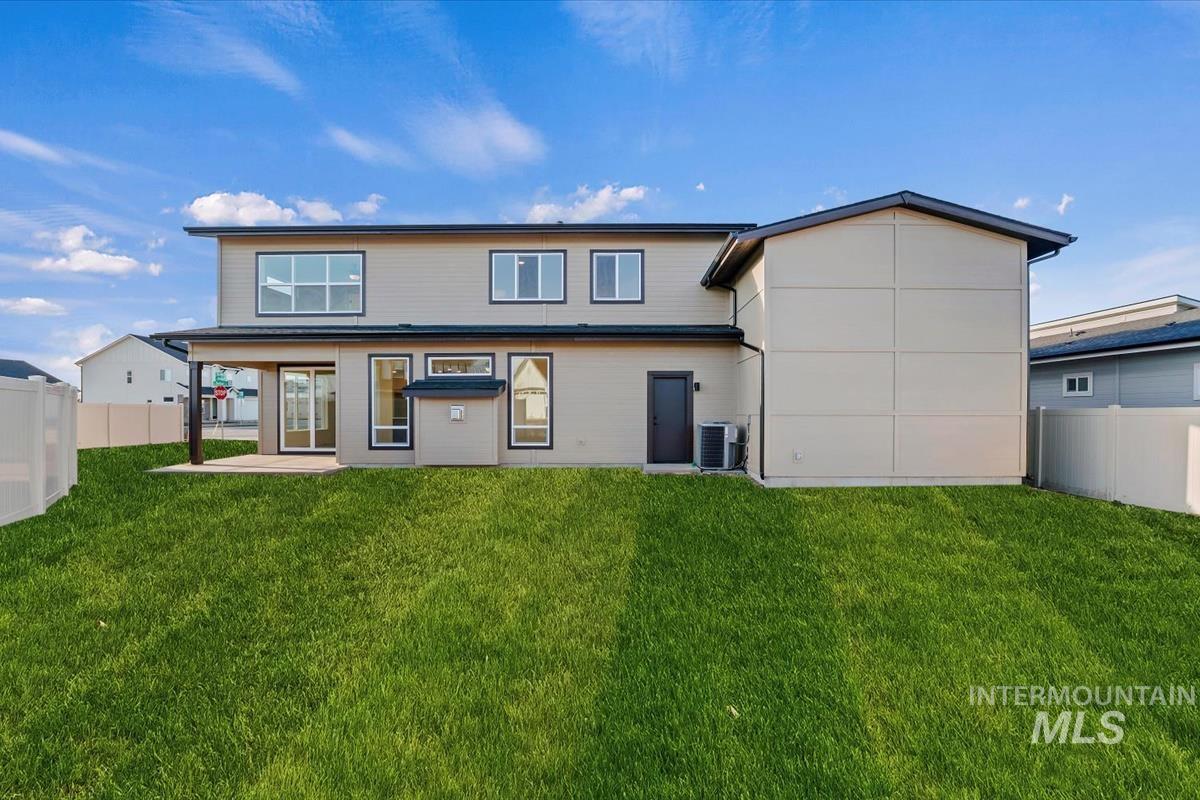 Back of house with a fenced backyard and a patio