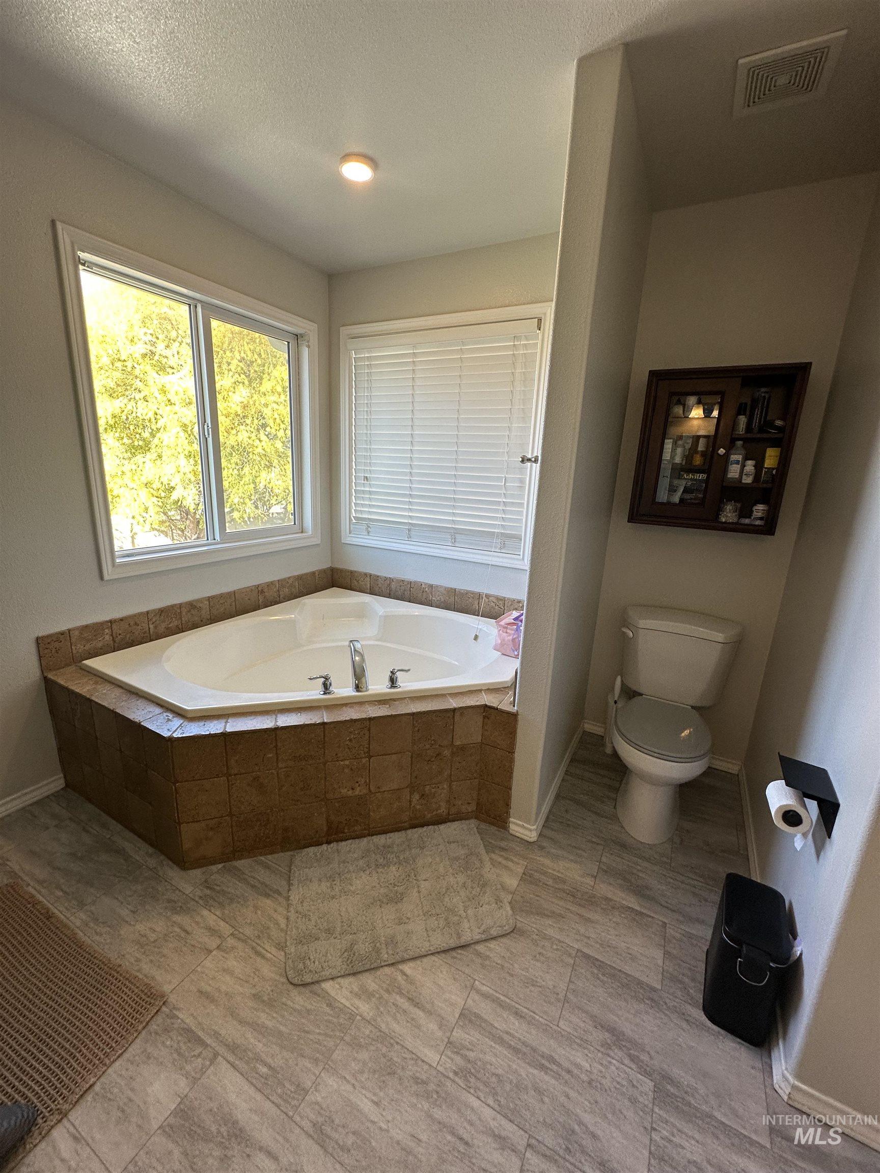 Bathroom with a bath and a textured ceiling