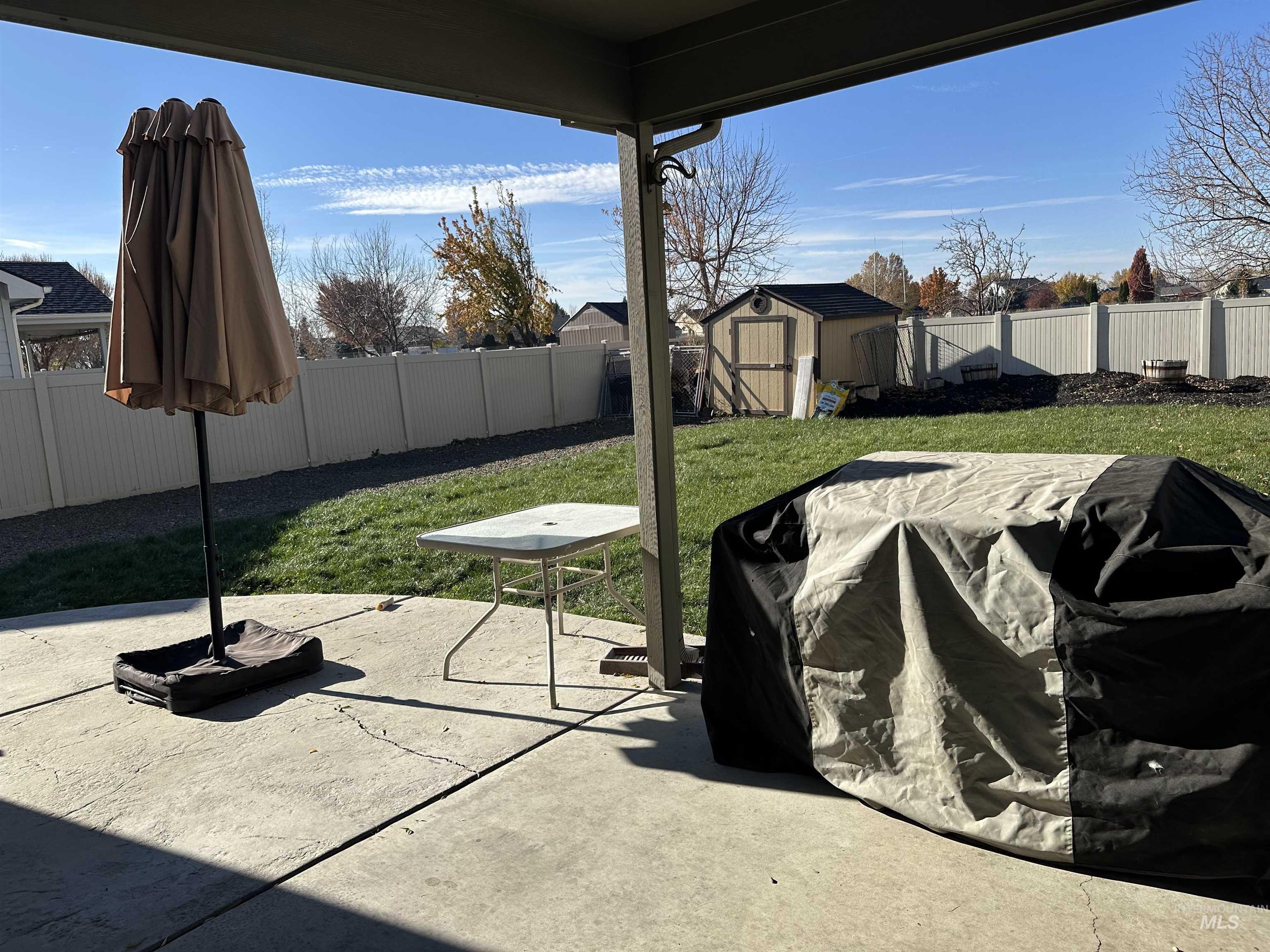 Fenced backyard with a patio and a storage shed