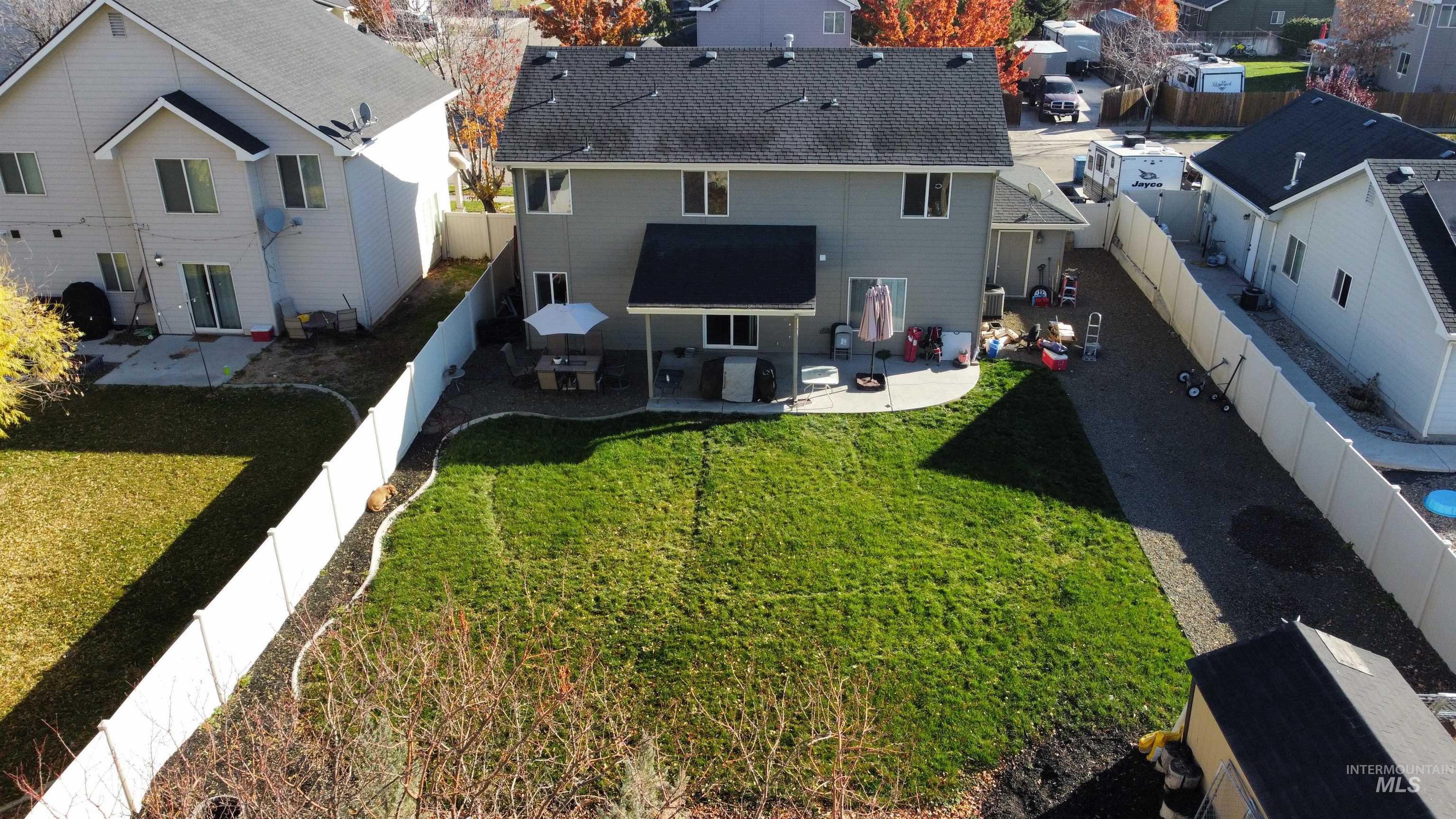 Rear view of house featuring a fenced backyard, a patio area, and a residential view