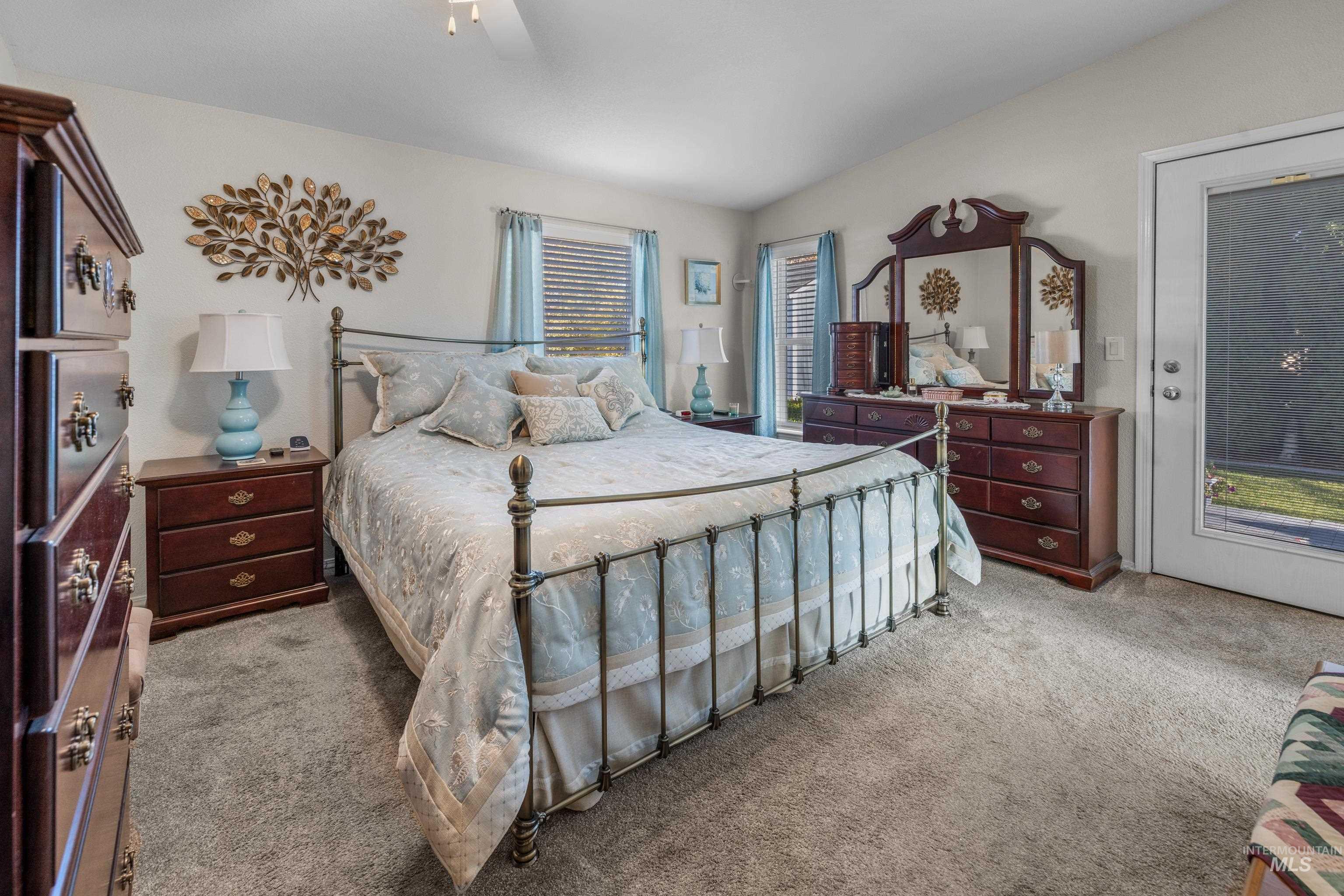 Carpeted bedroom with a ceiling fan