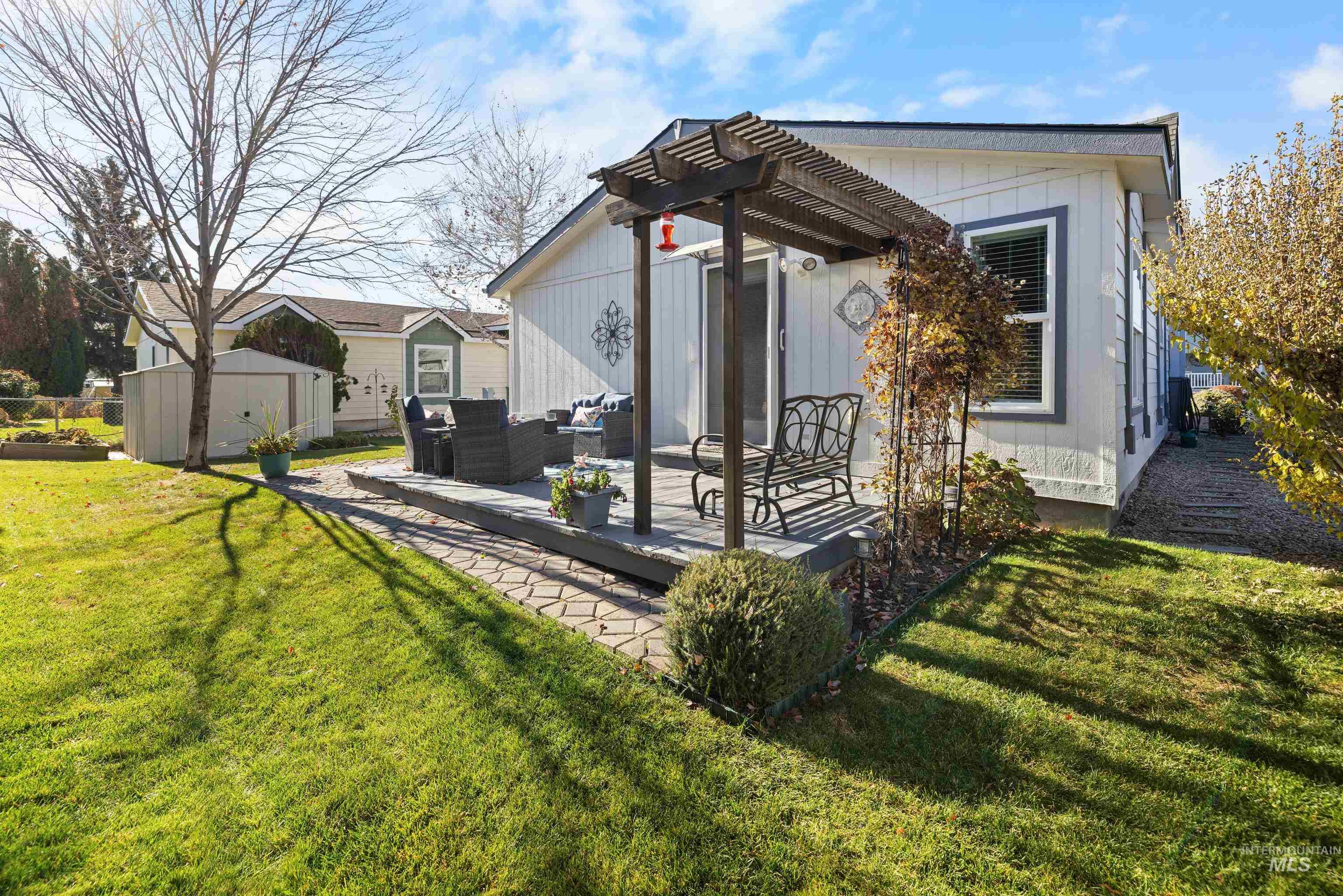 Back of property featuring an outdoor hangout area, a shed, a patio, and a lawn